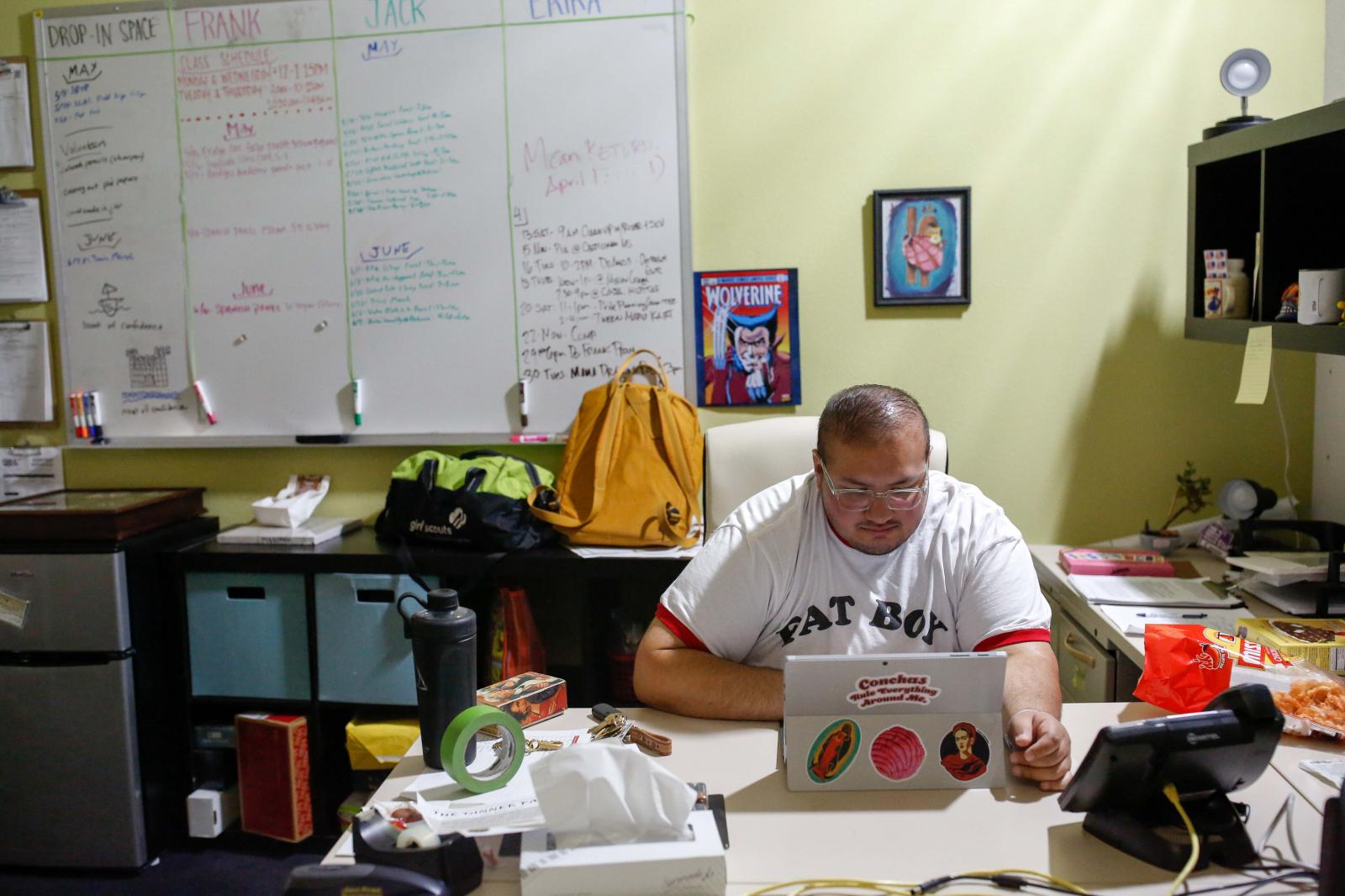 Frank Pe&ntilde;a, 27, responds to work emails at the San Jose LGBTQ Youth Space where he...