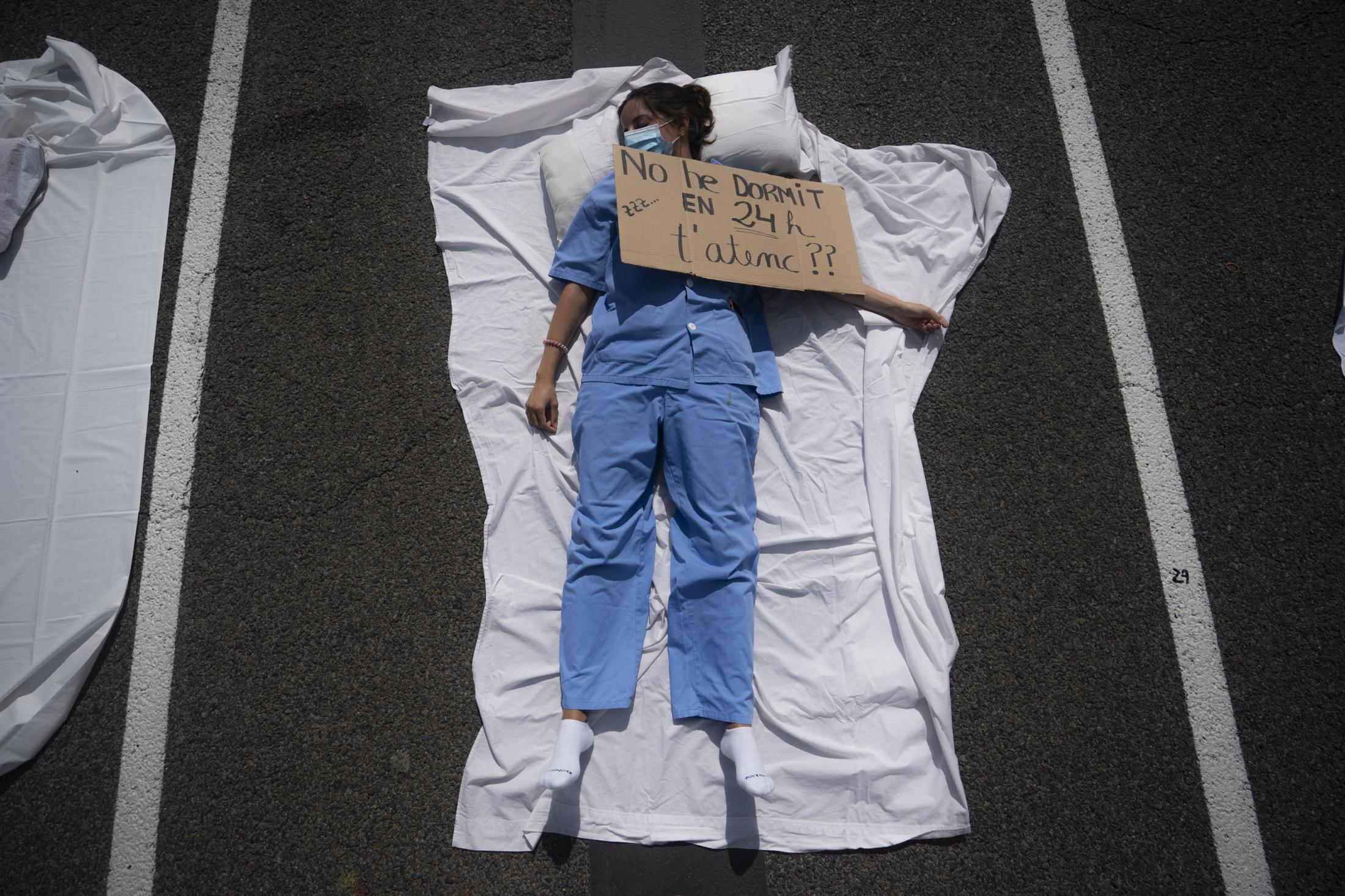 Singles -  A resident doctor lays on the ground of an avenue with a...