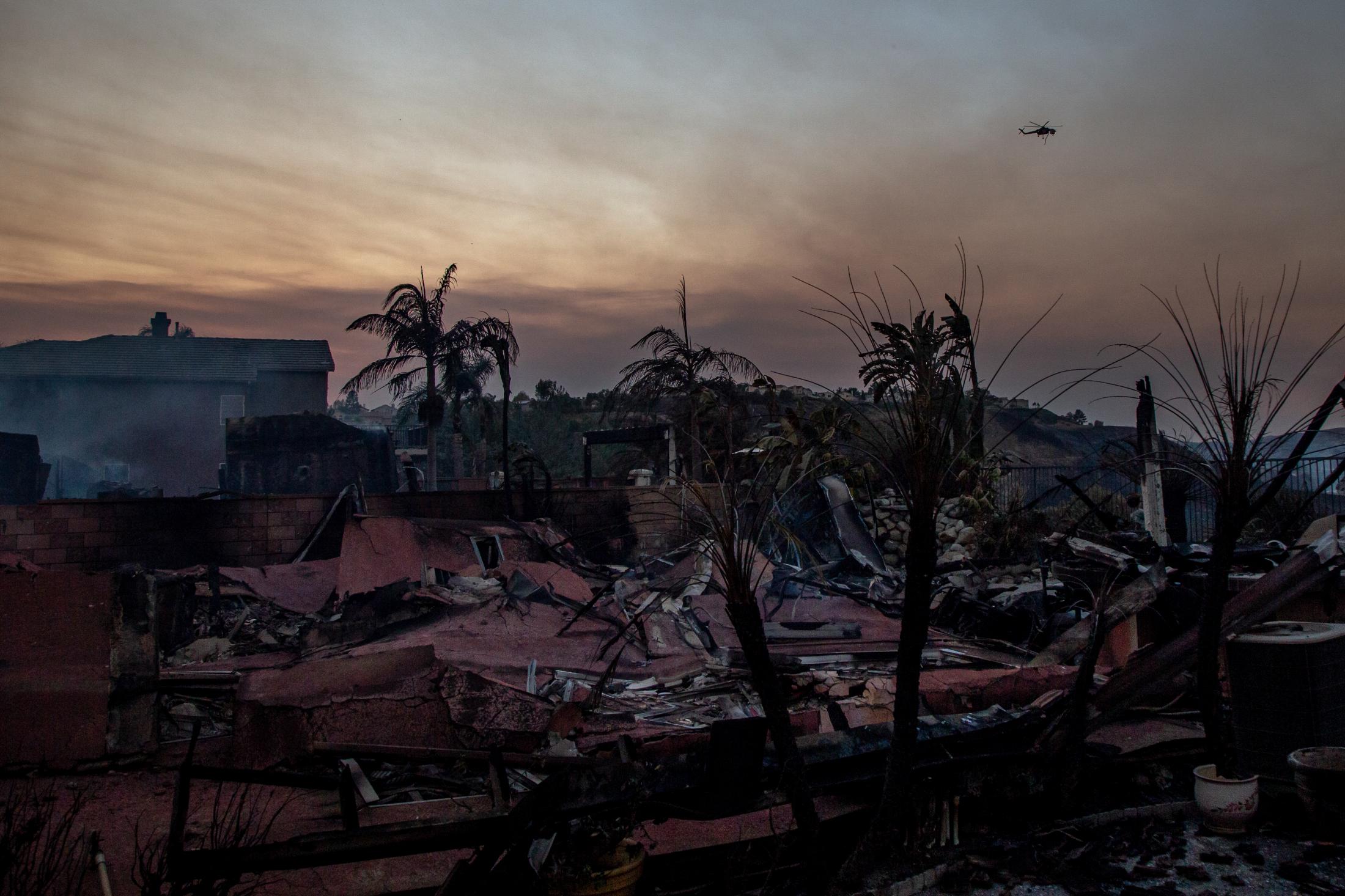 Nature of Fire - A helicopter flies over a neighborhood that has been...