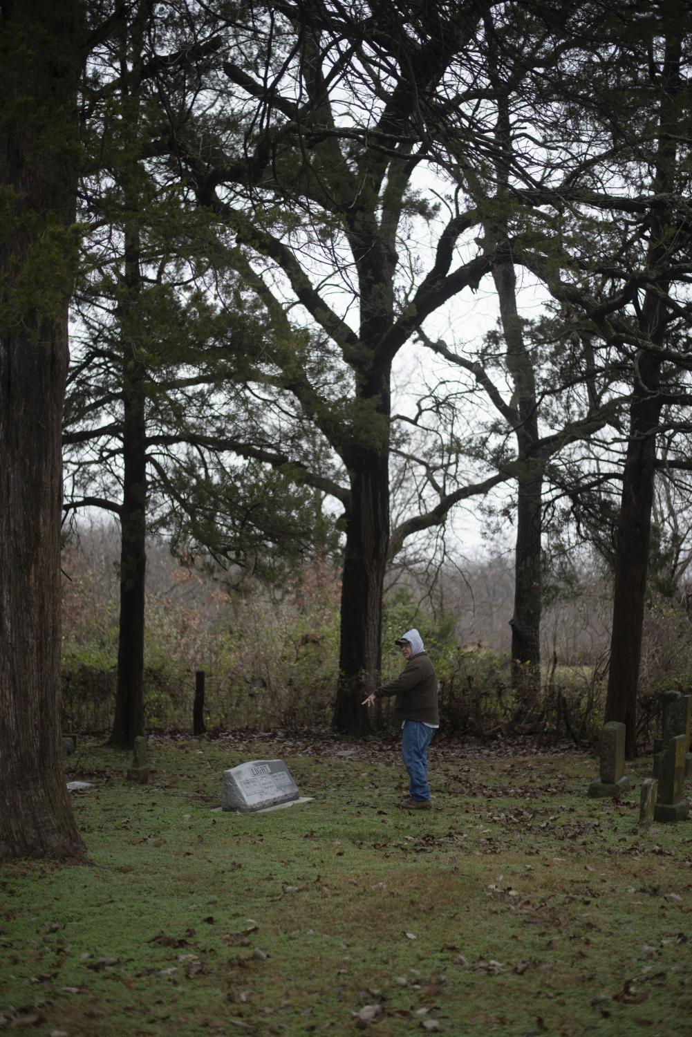 My grandfather, Ron Reed, gestures to a headstone Nov. 25 at Fairview Rider Cemetery. His grandparents are buried in the cemetery alongside other unknown Reeds.