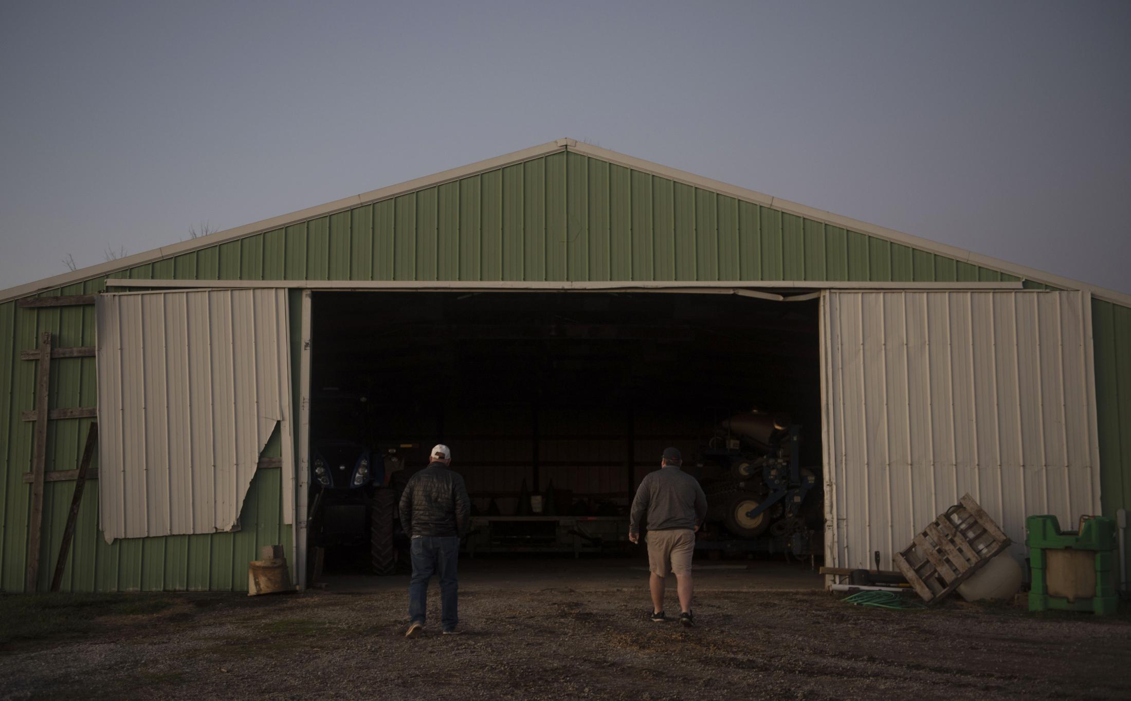 From left, Rusty Reed and his nephew Marty Reed walk into a machine shed Dec. 4. Rusty lives in...