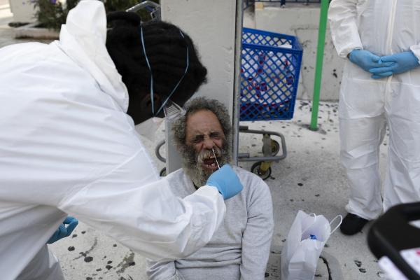 A worker of Miami-Dade County Homeless Trust takes a sampler test to a homeless for coronavirus disease (COVID-19) in Downtown Miami on April 16, 2020. Eva Marie UZCATEGUI