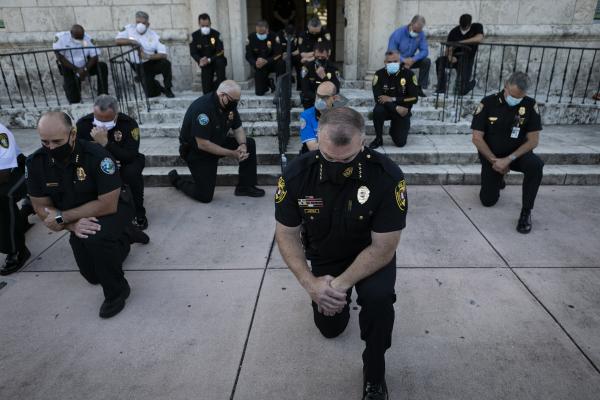 Police officers kneel during a rally in response to the recent death of George Floyd in Coral Gables, Florida on May 30, 2020. Eva Marie UZCATEGUI