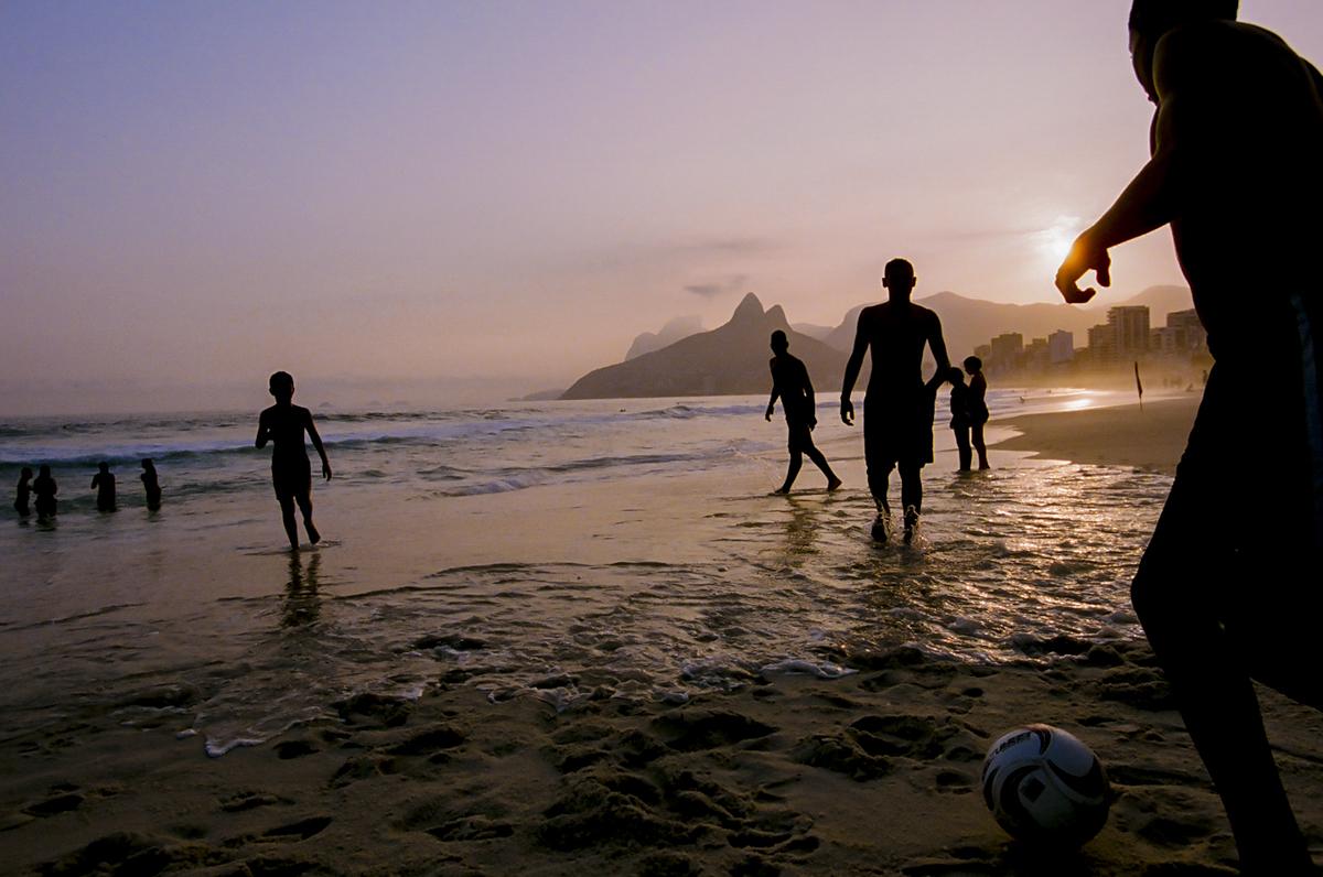 A group of boys jungle a soccer ball on Ipanem