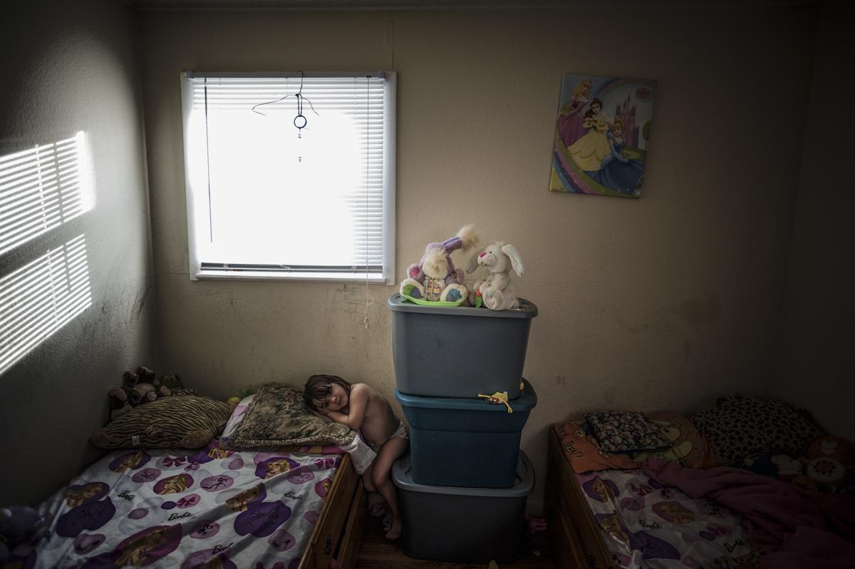 Danika Garcia, 5, crouches in her room in Gorham, Maine, while her parents speak to legal services about her father Fidel's possible...
