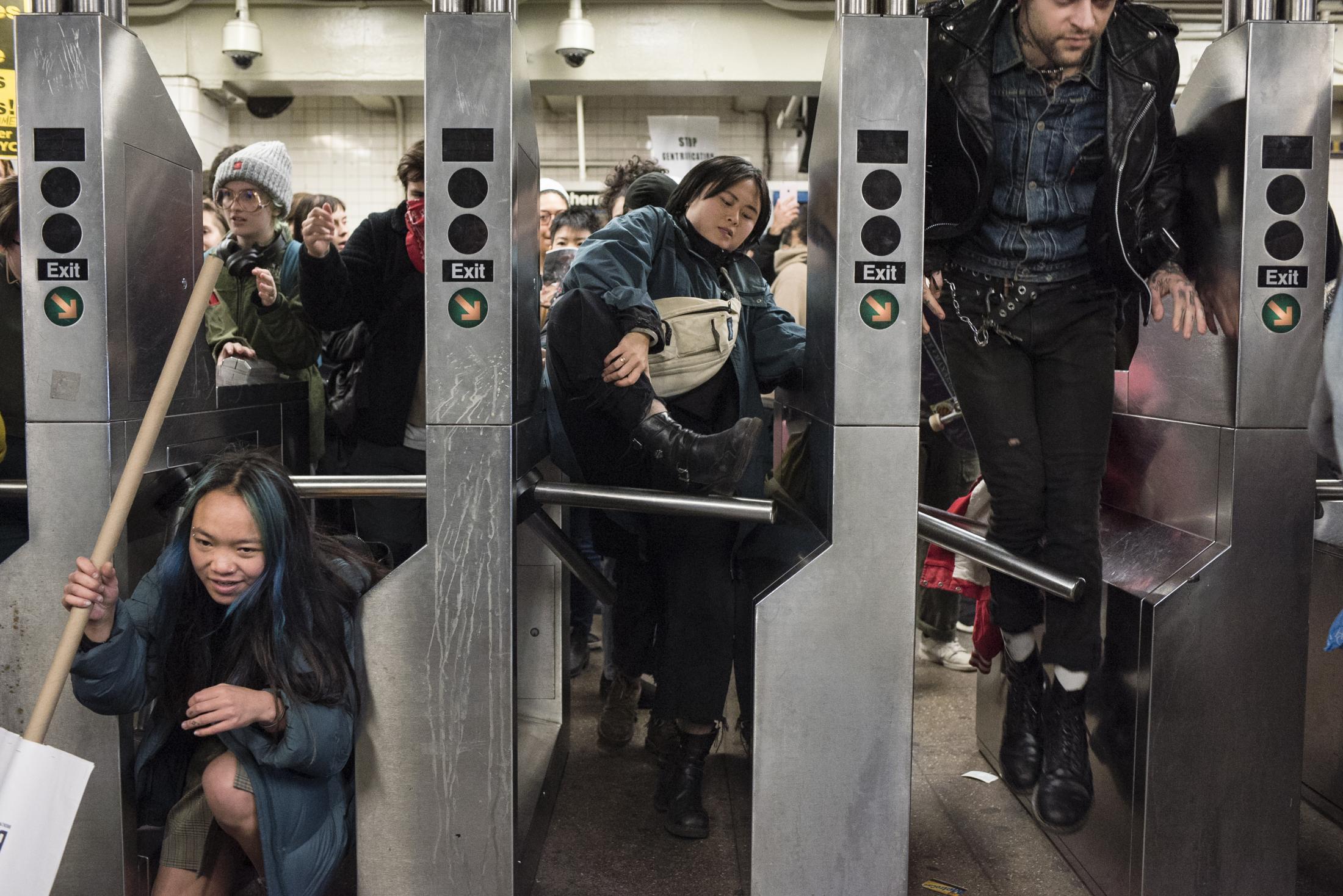 A group of protesters is seen jumping the turnstiles of the MTA in NY as a protest for the...
