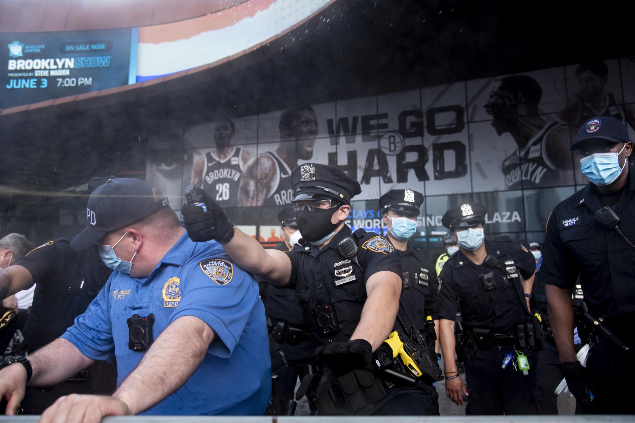 An NYPD officer sprays a group of protesters congregated at Barclay&#39;s Center in Brooklyn,...