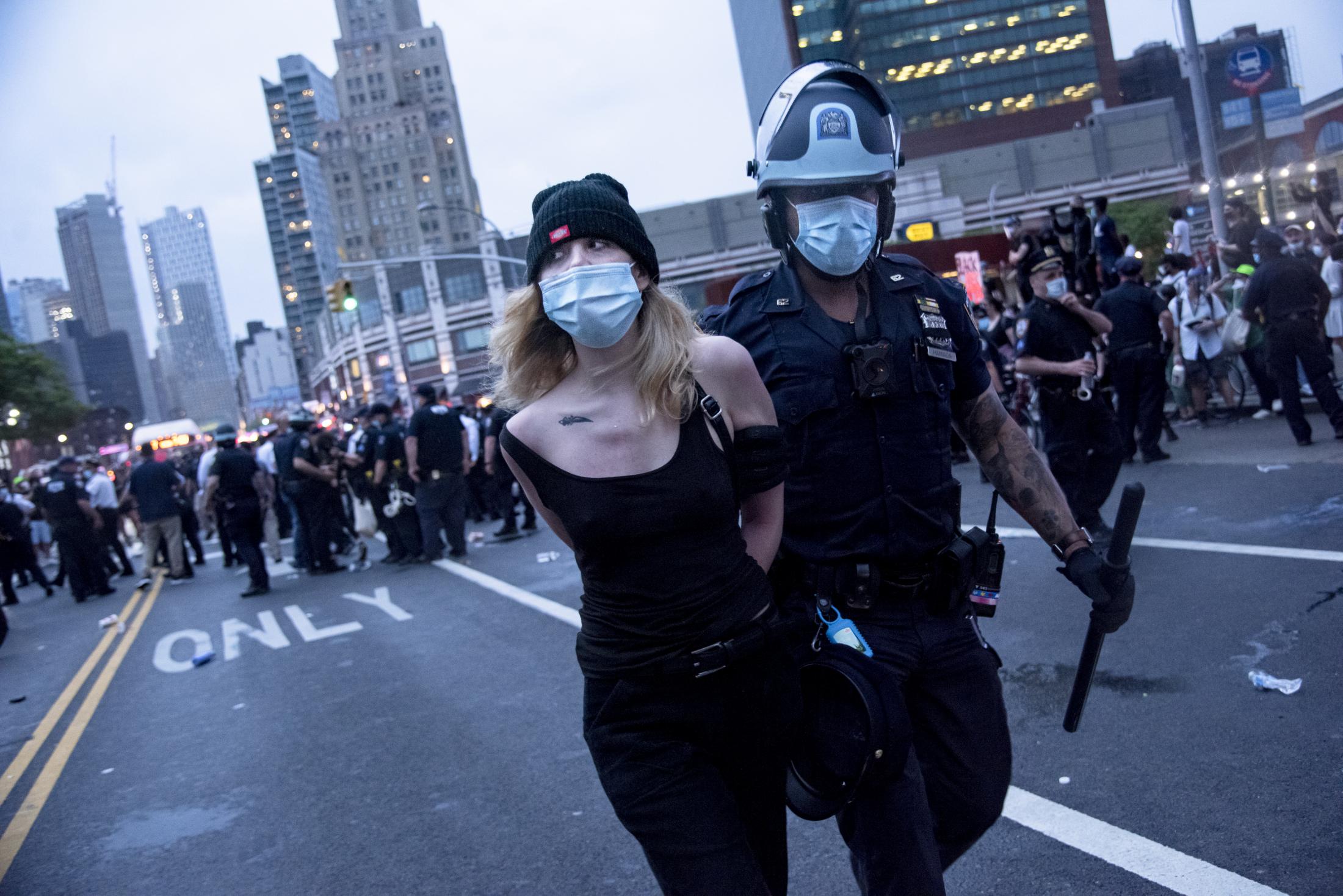 A young woman is detained by an NYPD officer on the first day of protest in support of George...