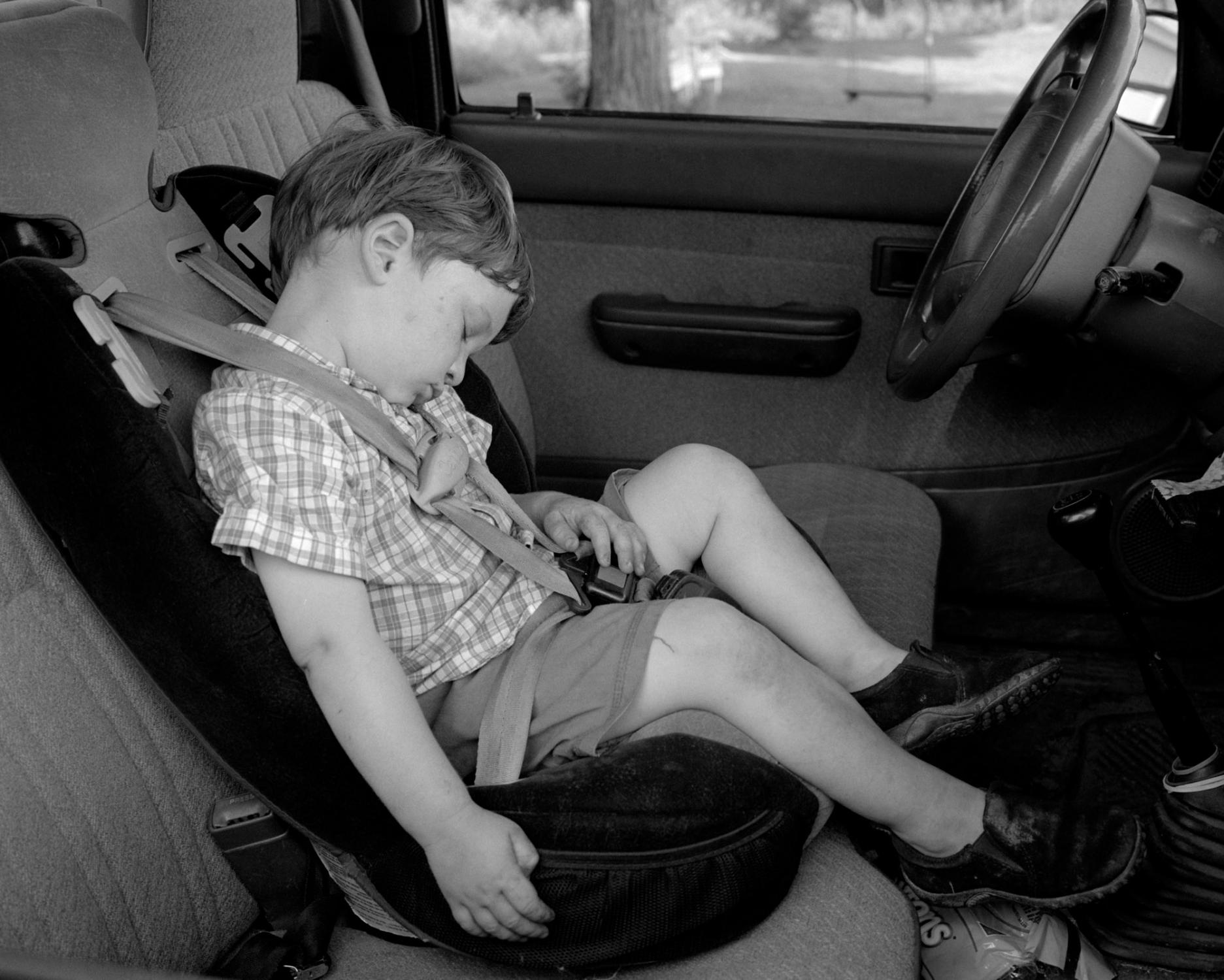 American Moments - Henry (2) is sleeping in his father’s truck at Lilac...