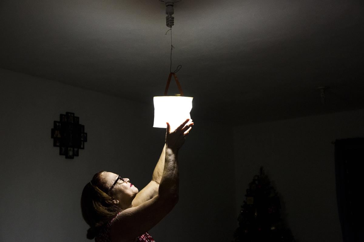 Memorias de Septiembre - Julia Guzmán Serrano, 65, hangs a solar lamp in...