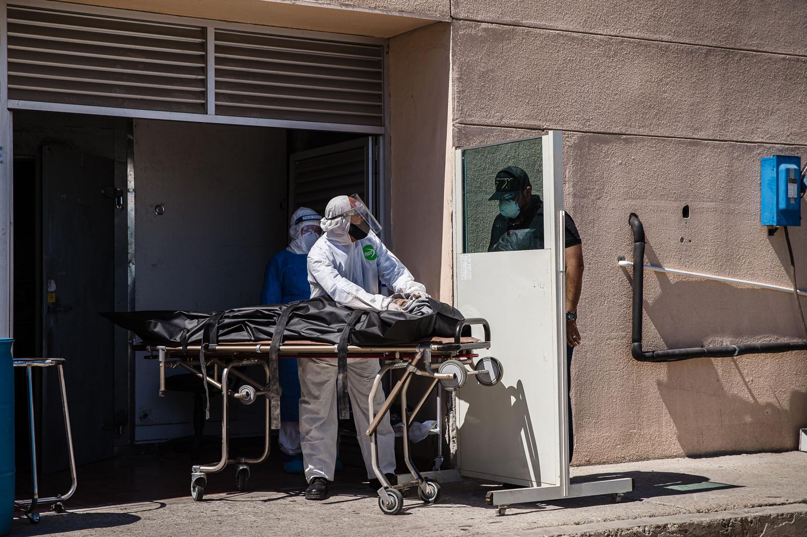 A man identifies his 74 year old father behind a protective panel who died from COVID-19-related complications at General Hospital No.1 in Tijuana, Mexico on May 6, 2020.