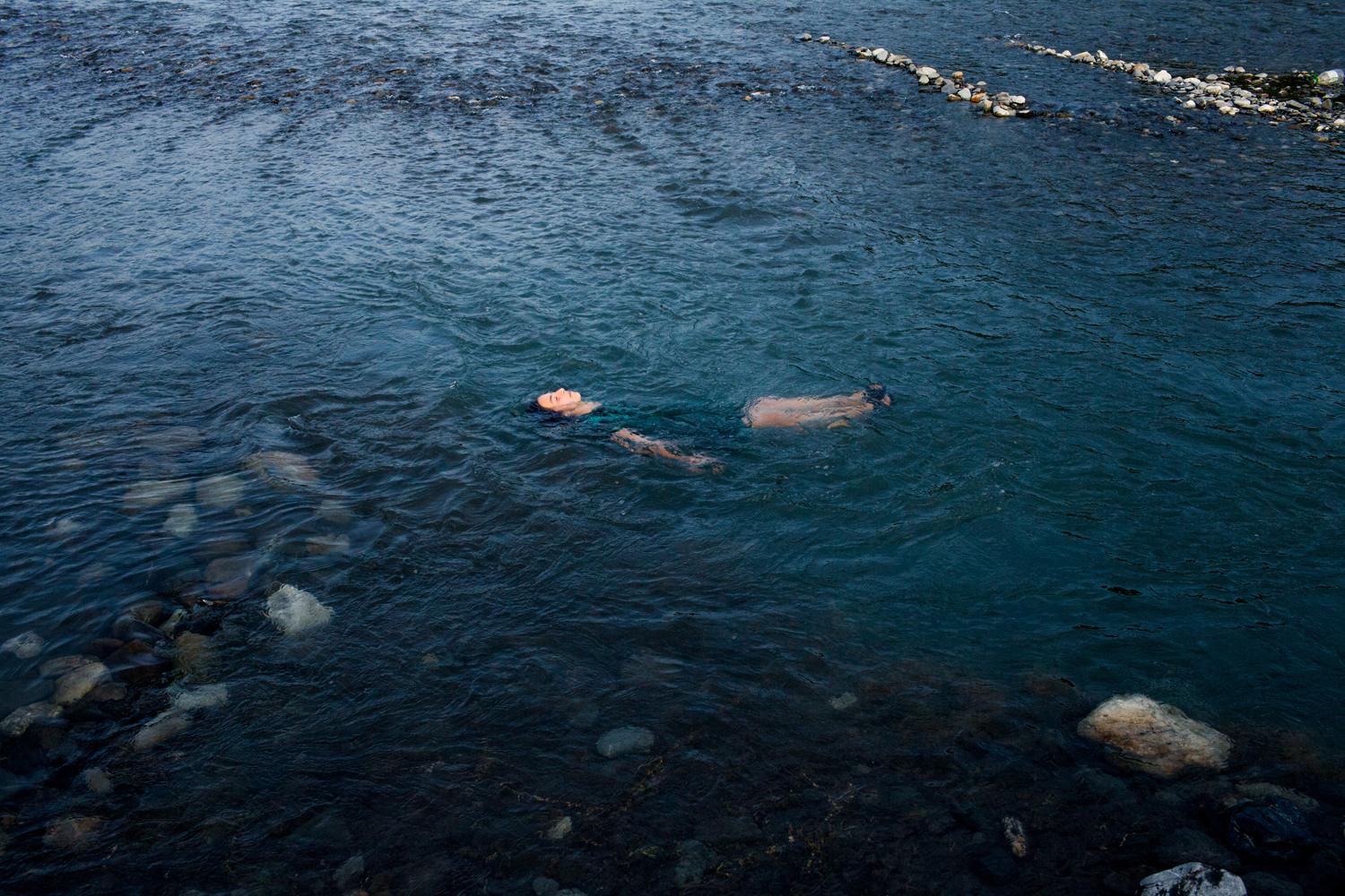 Mari floating and dreaming in Alazani River. Duisi Village. Pankisi Gorge. Georgia. 2015