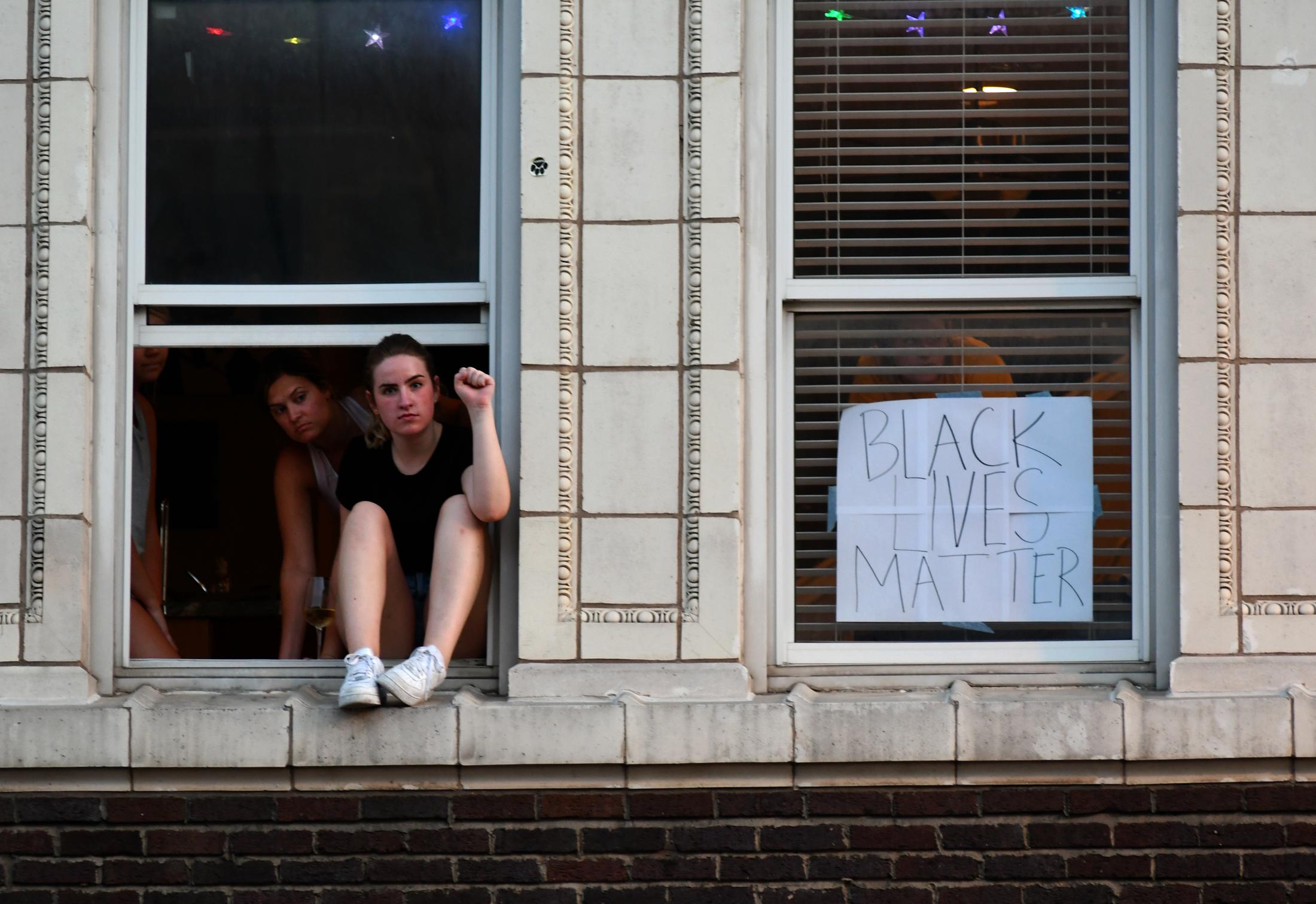From a building, people watch in support of protesters blocking the intersection of East Broadway and North Eighth Street on Tuesday, June 2, 2020,...
