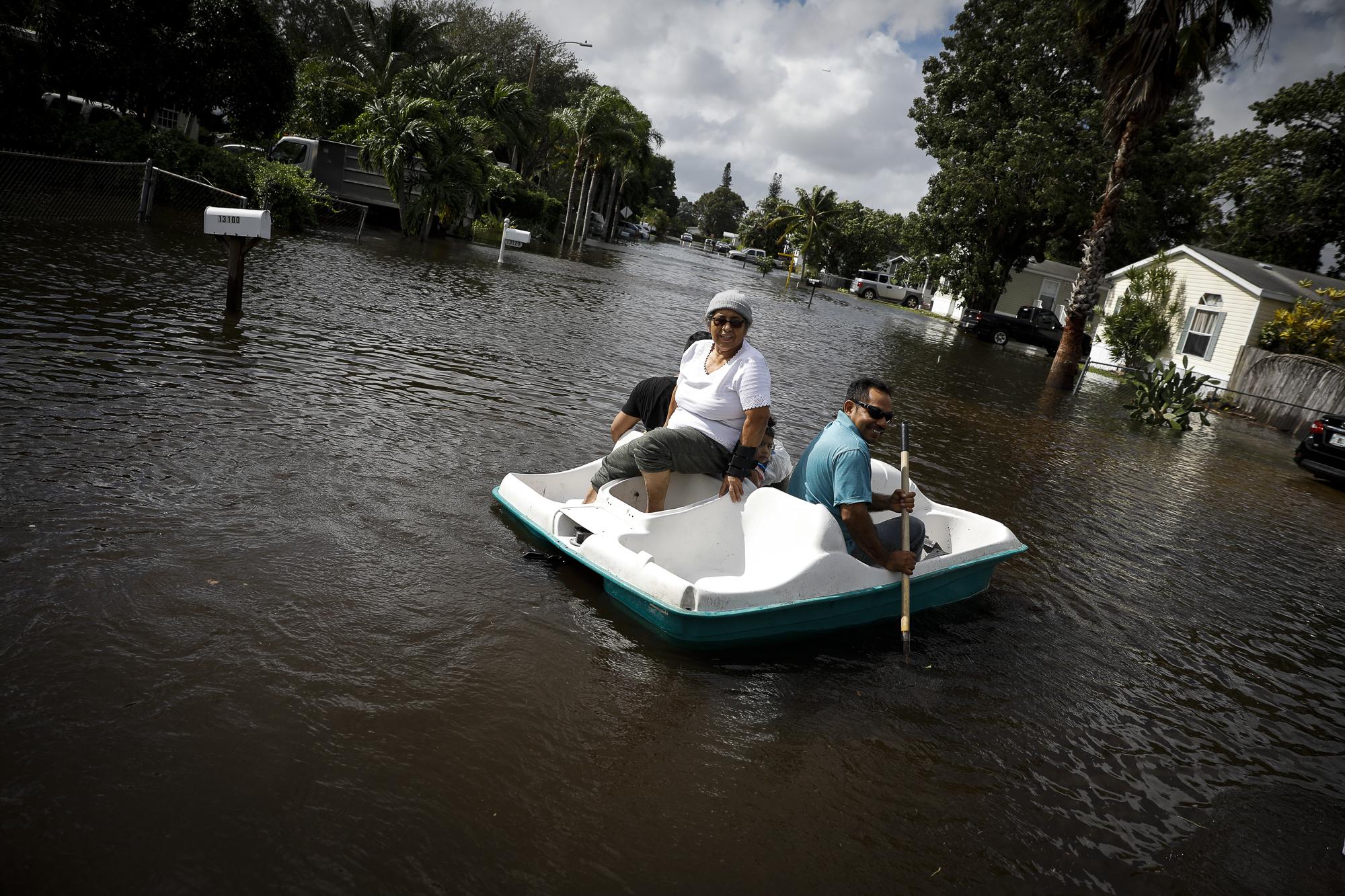 Tropical Storm Eta drenches South Florida - People row a boat in floodwaters caused by Storm Eta in...