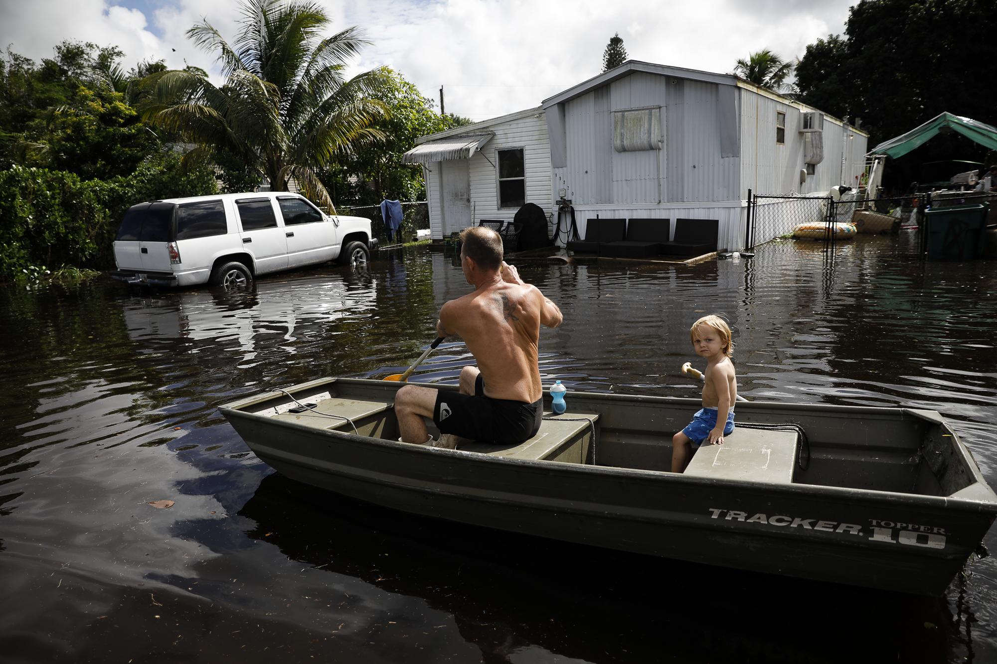 Tropical Storm Eta drenches South Florida - A man rows a boat in floodwaters caused by Storm Eta in...