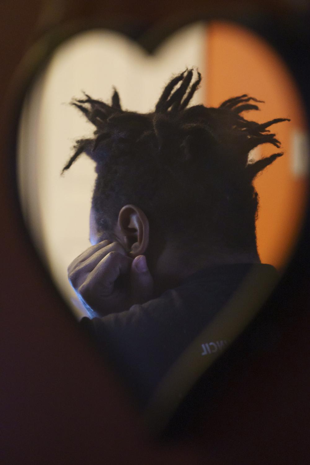 Troy Gaston, reflected in a mirror, attends a virtual Cook County court hearing for a motion to have his case dismissed at his home in West...