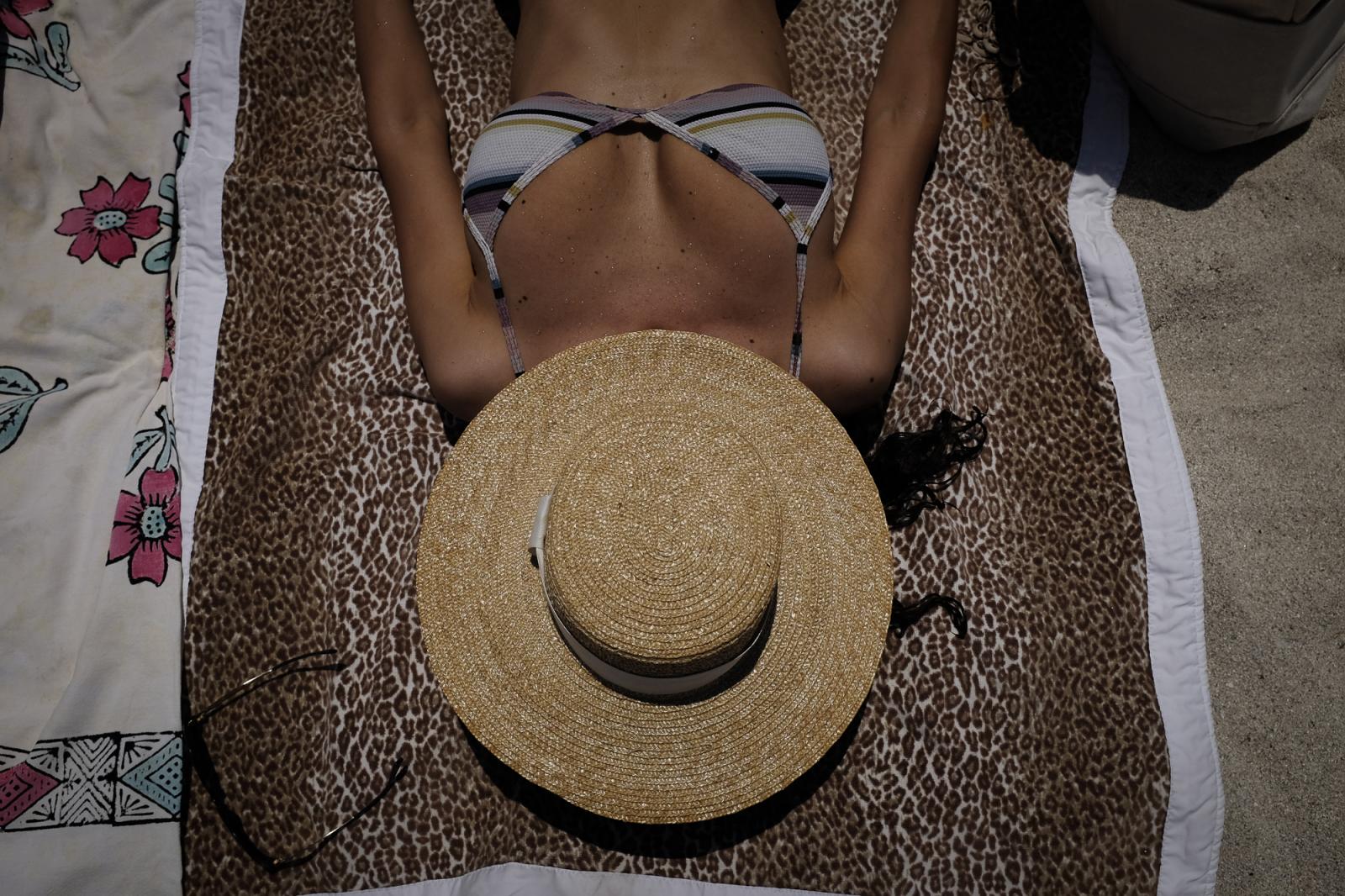 A woman sunbathes as beaches ar...e 10, 2020. REUTERS/Marco Bello