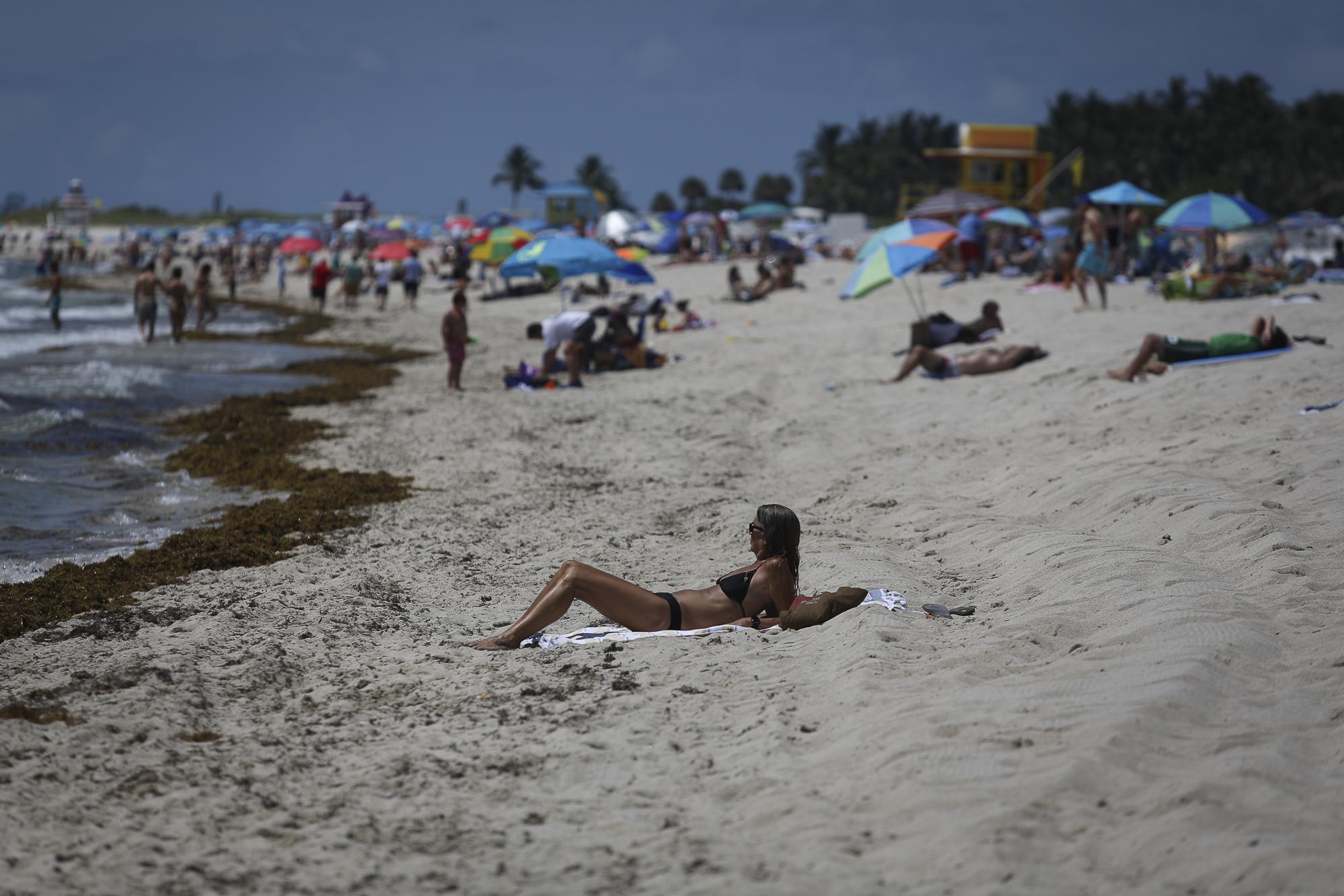 Beaches reopen with restrictions to limit the spread of the coronavirus disease  - A woman sunbathes as beaches are reopened with...