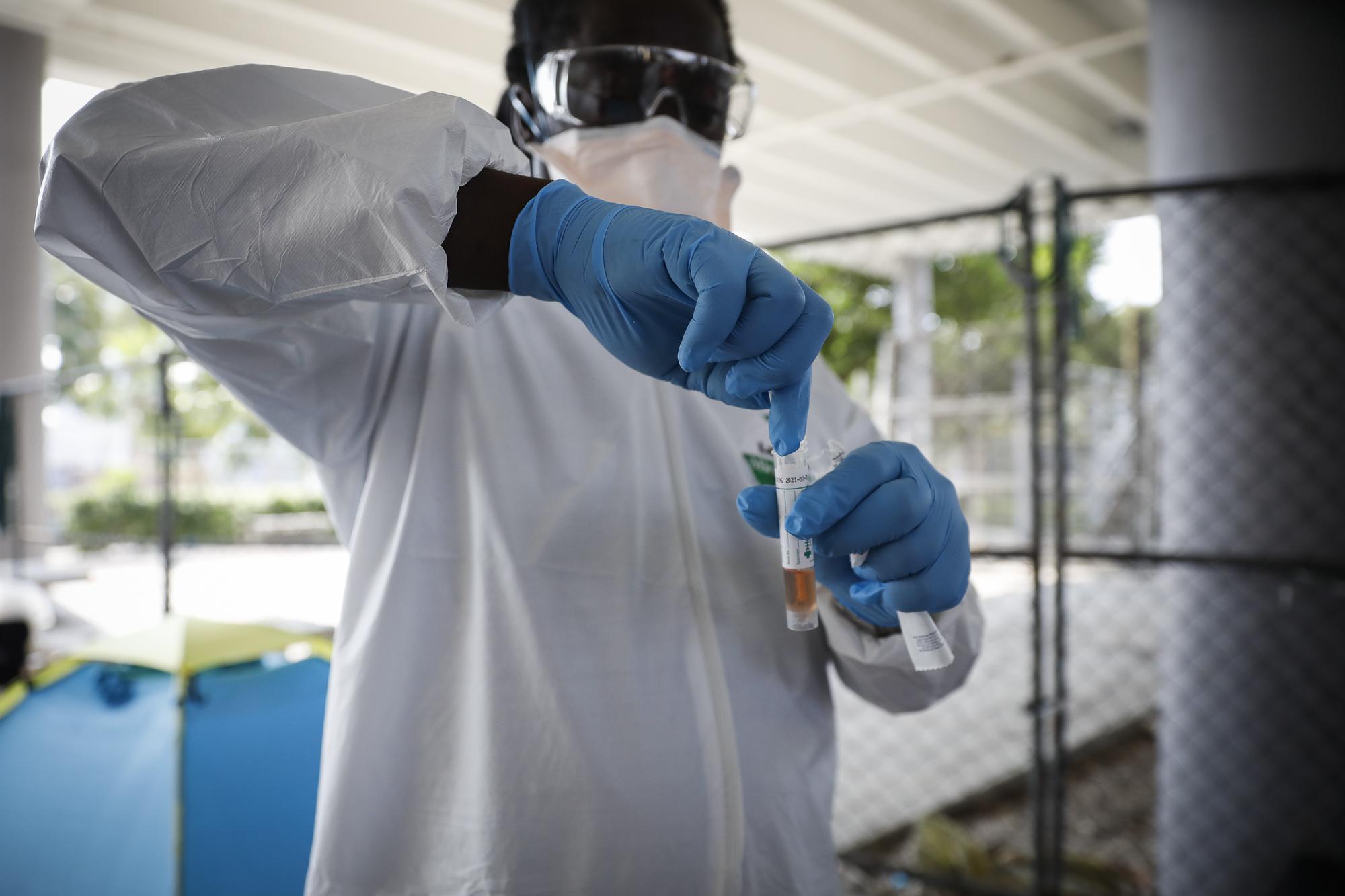 A worker holds a sample collected from a homeless man during a Miami-Dade County testing operation for the coronavirus disease (COVID-19), in downtown Miami, Florida, U.S., April 16, 2020. REUTERS/Marco Bello