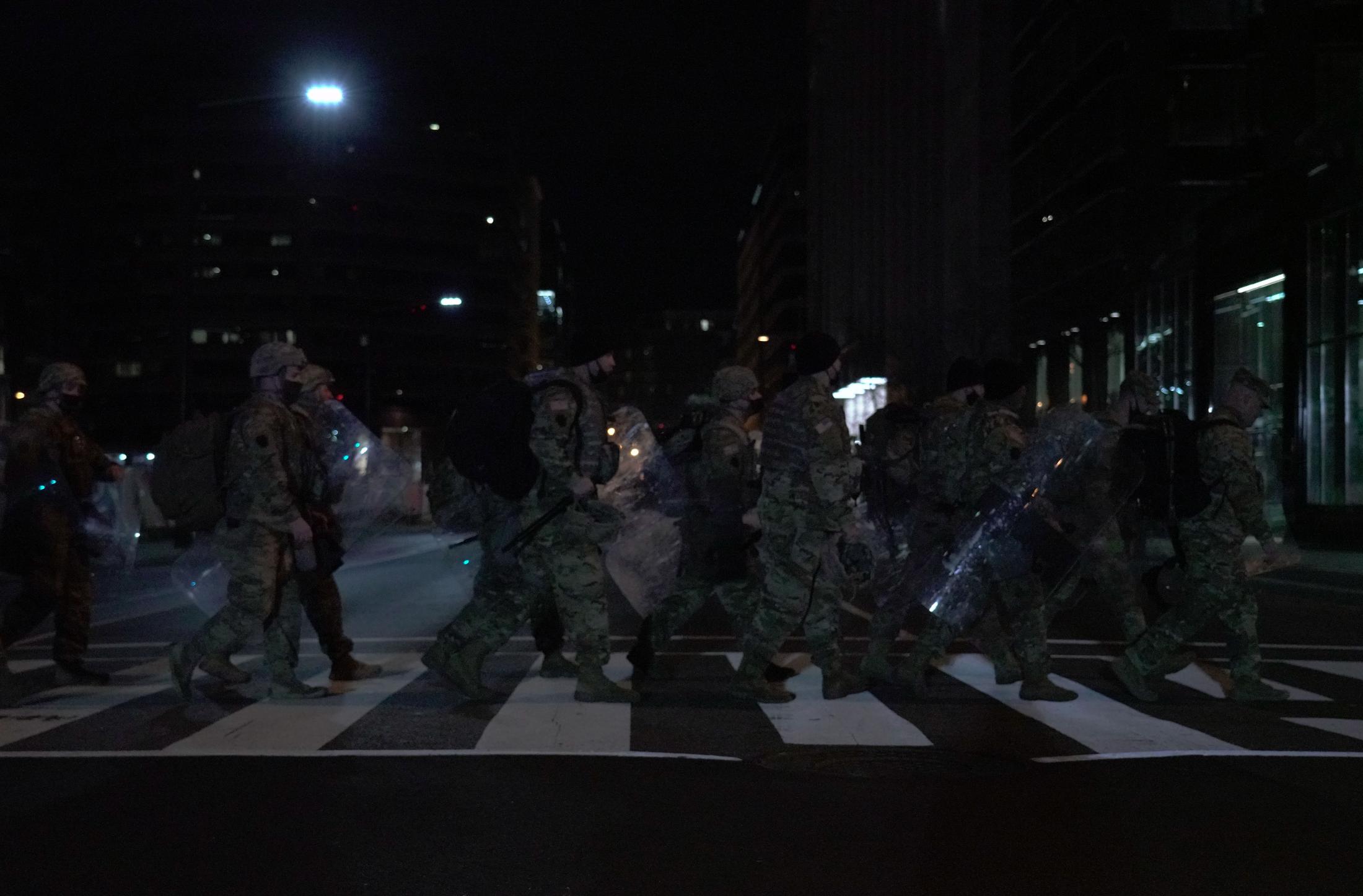 Occupied - National Guardsmen walk across a cross-walk during a...