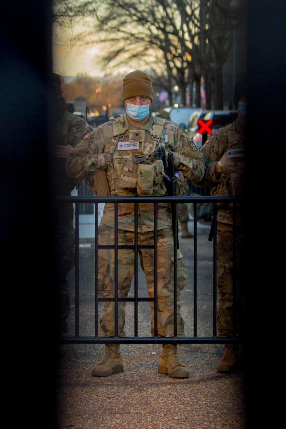 Portraits - A National Guard troop stands near a barricade by the...