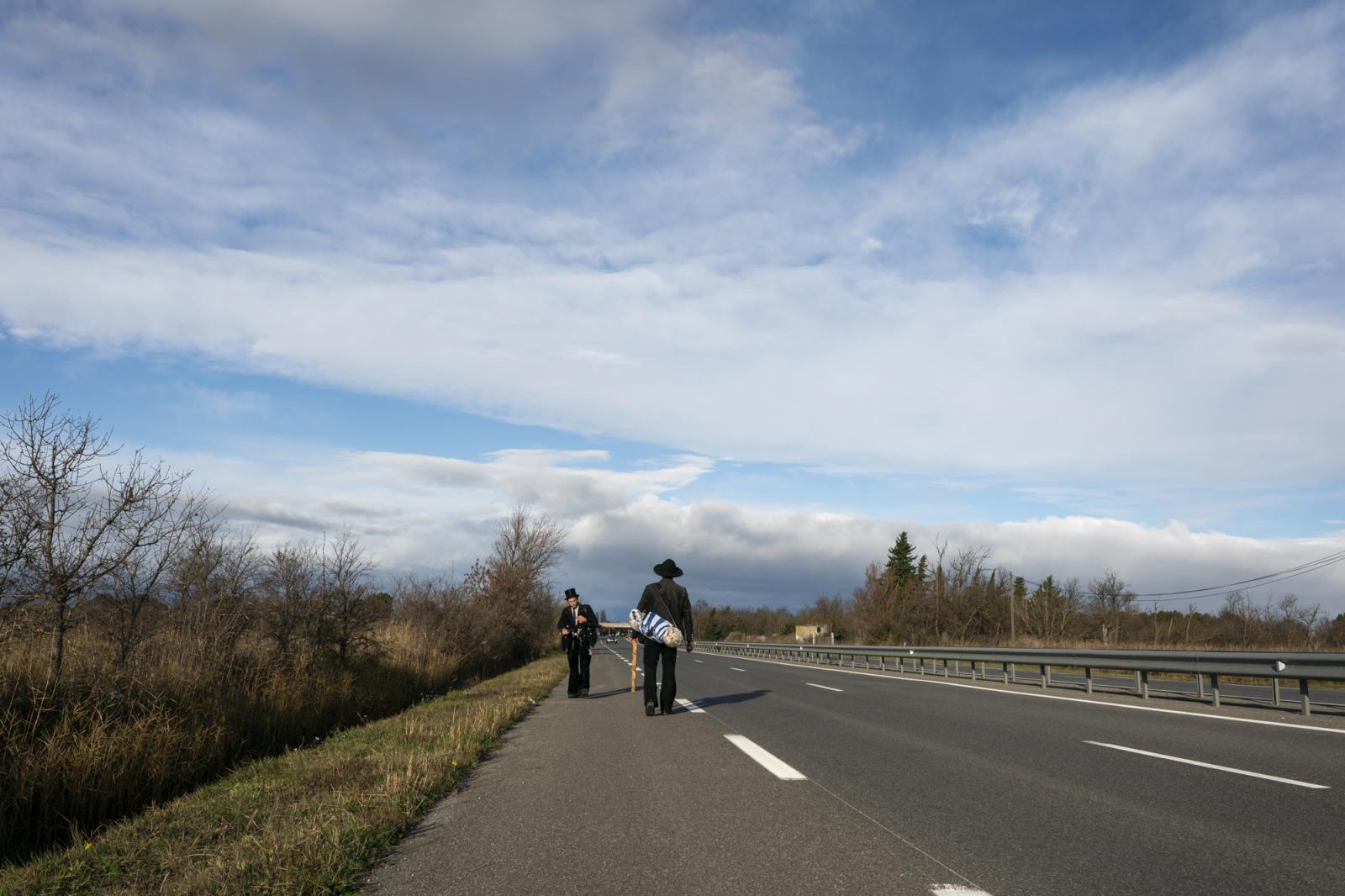   -  Matthias (L) and Ben walk along the empty road from Narbonne to Gruissan as they aim to reach...