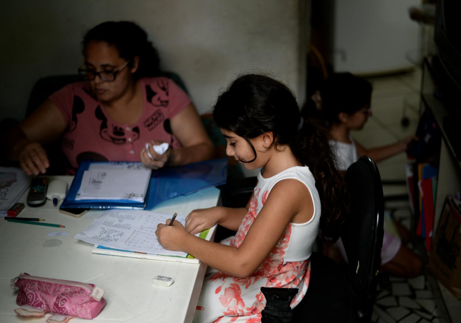 Celin Ibrahim, 7, center, finis...nt when doing their schoolwork.