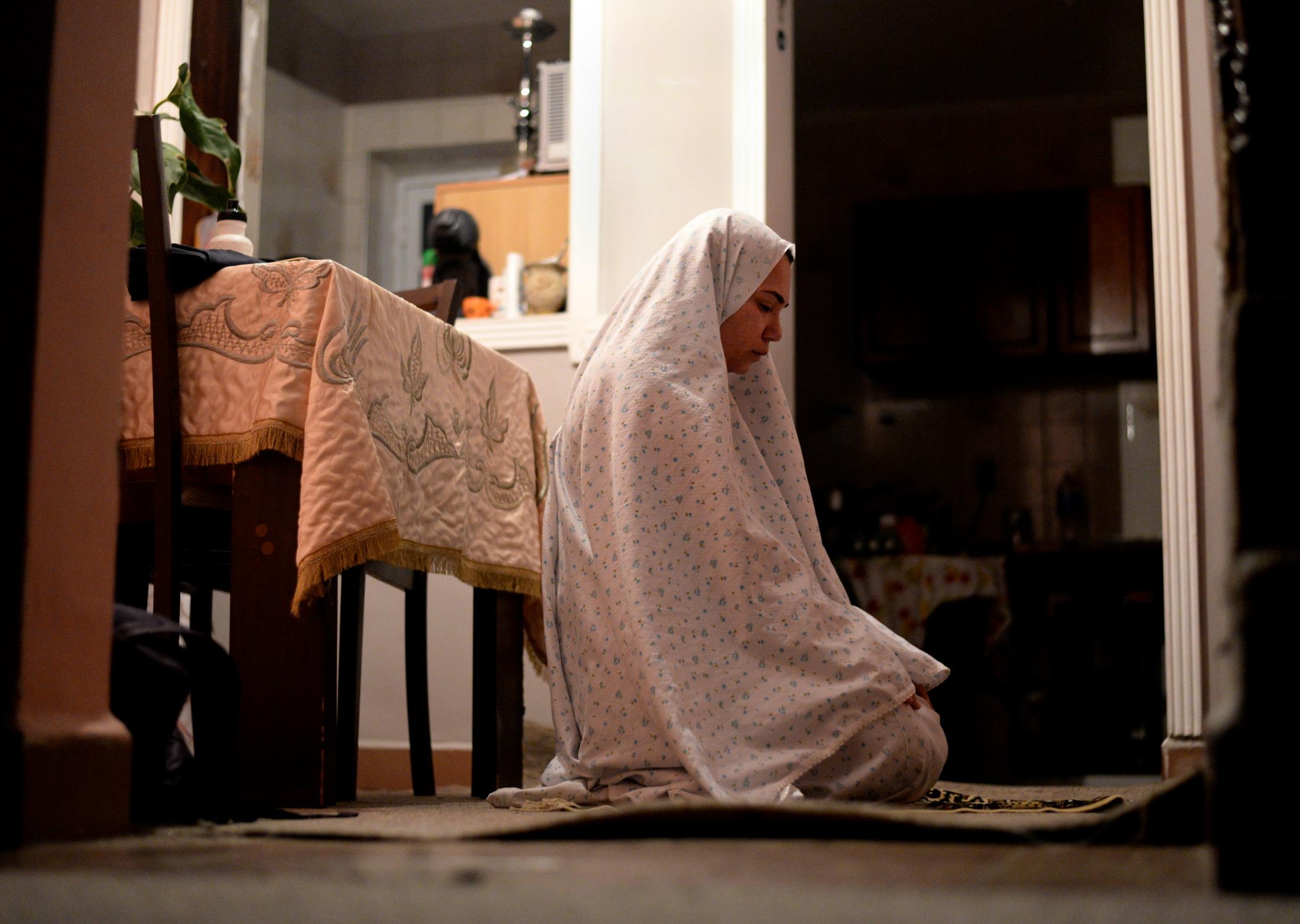 In Between Cultures - Rama AlOmari makes her first prayer before sunrise at her...