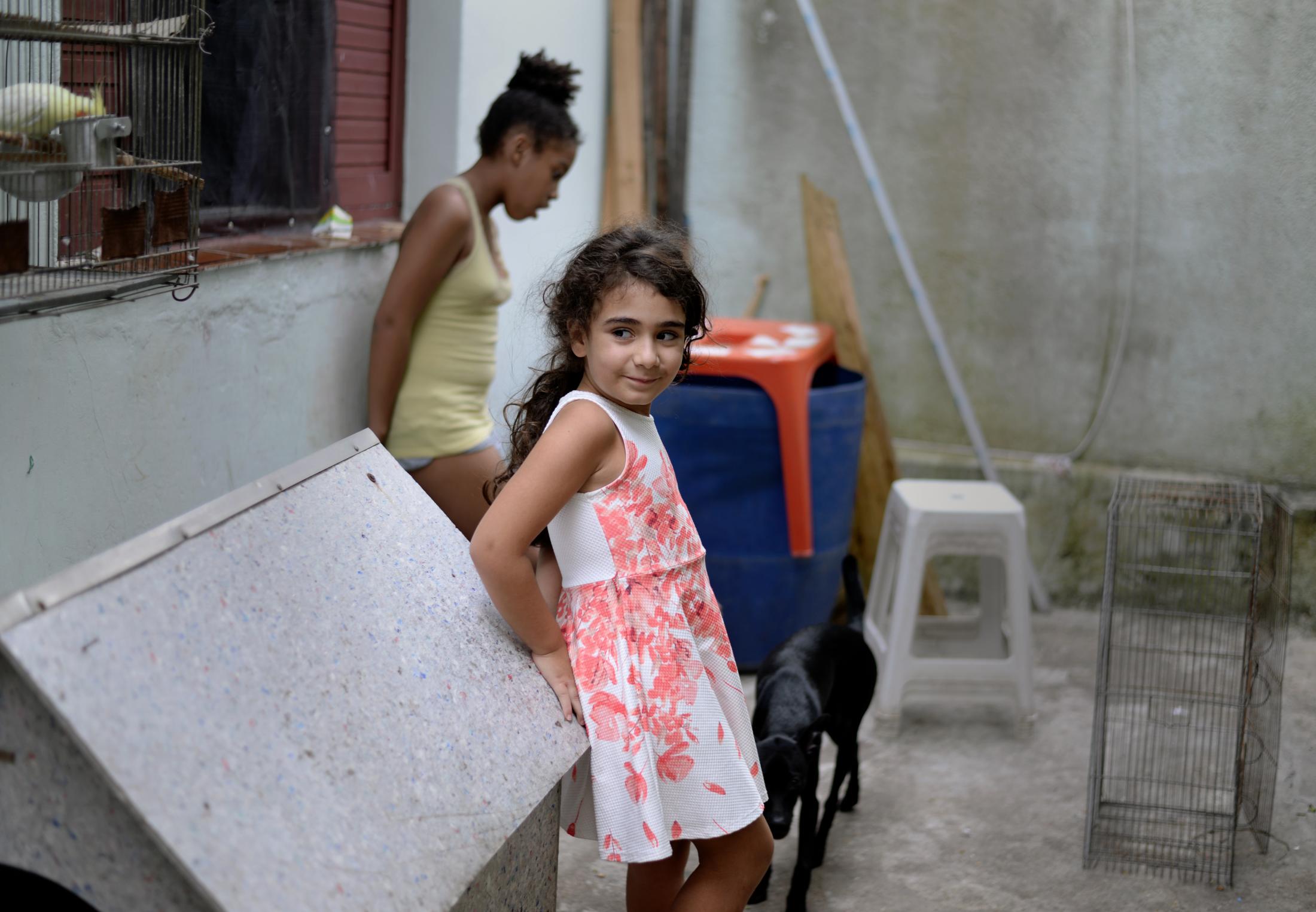 In Between Cultures - Celin Ibrahim, 7, waits for her sister Lamar, 8, so they...