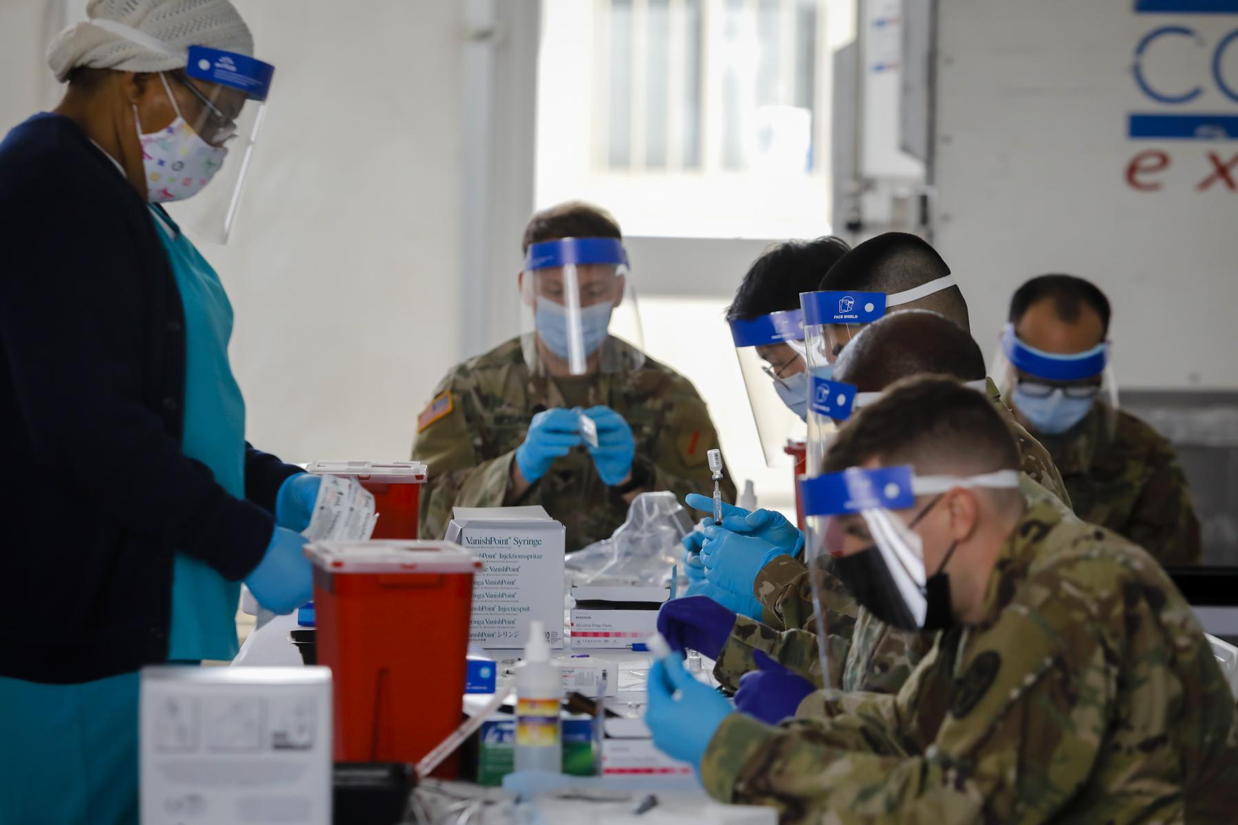 FEMA vaccination facility in North Miami - U.S. Army soldiers prepare Pfizer COVID-19 vaccines to...