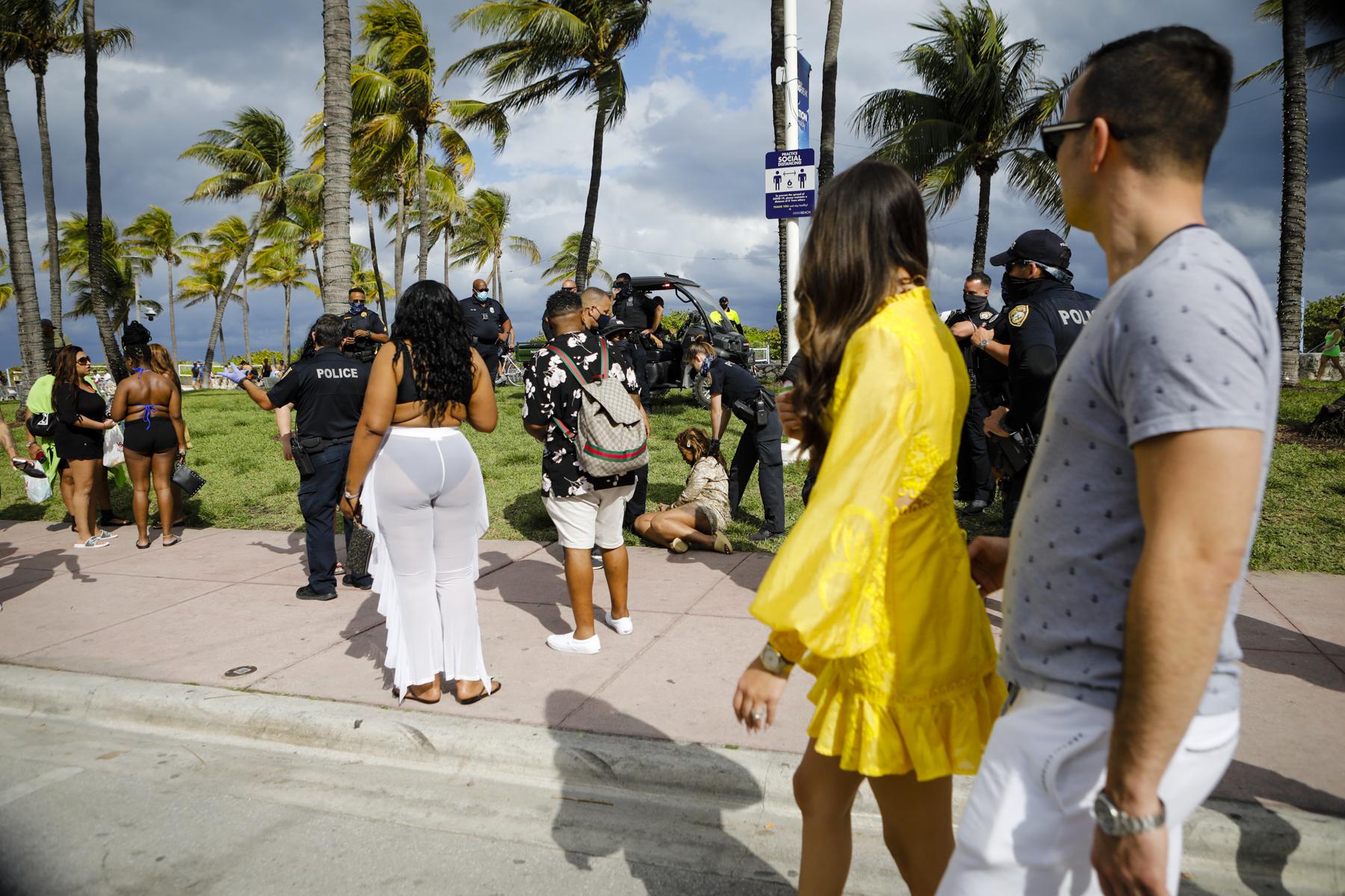 2021 Spring Break @ Miami Beach - Police officers help a woman during Spring Break in Miami...
