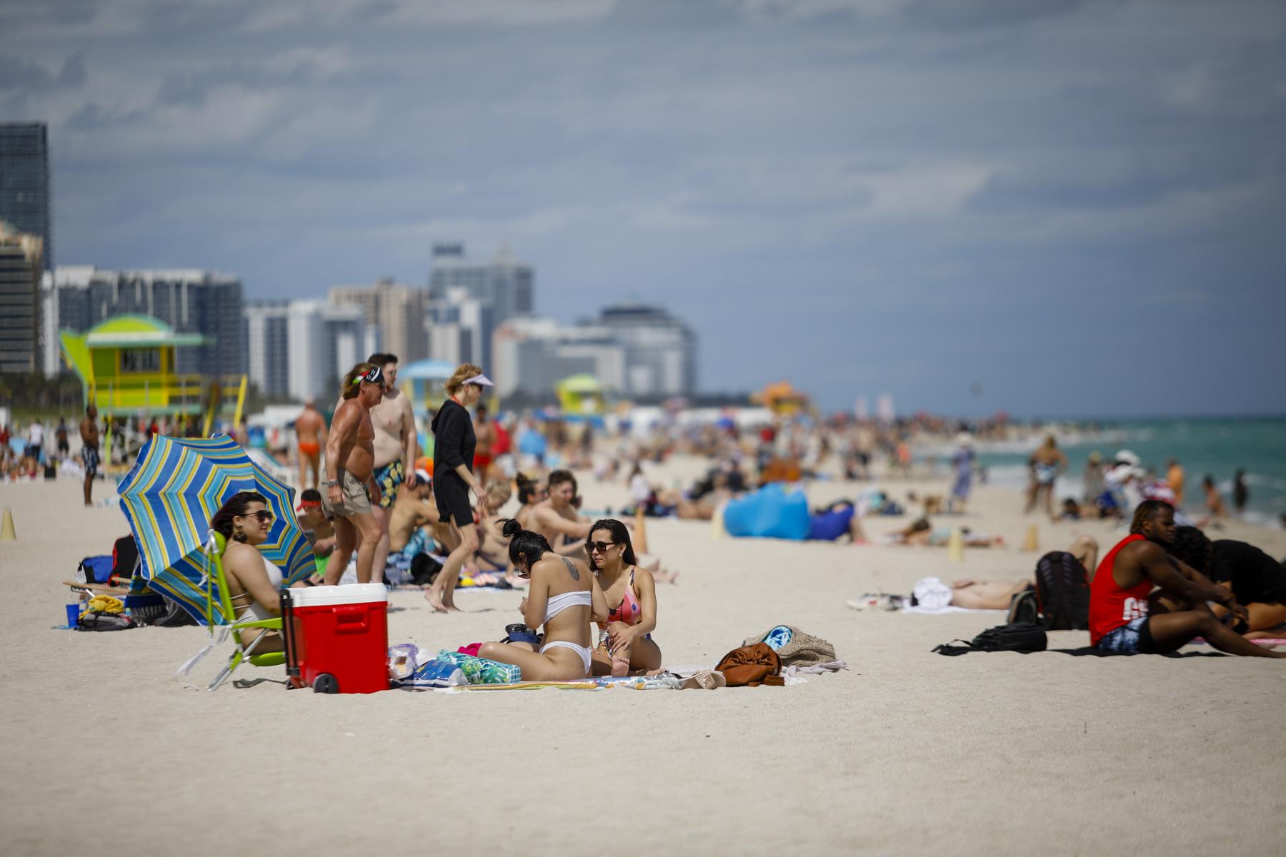 People sit on the beach during Spring Break in Miami Beach, Florida, U.S., on Saturday, March 6, 2021. Photographer: Eva Marie Uzcategui/Bloomberg