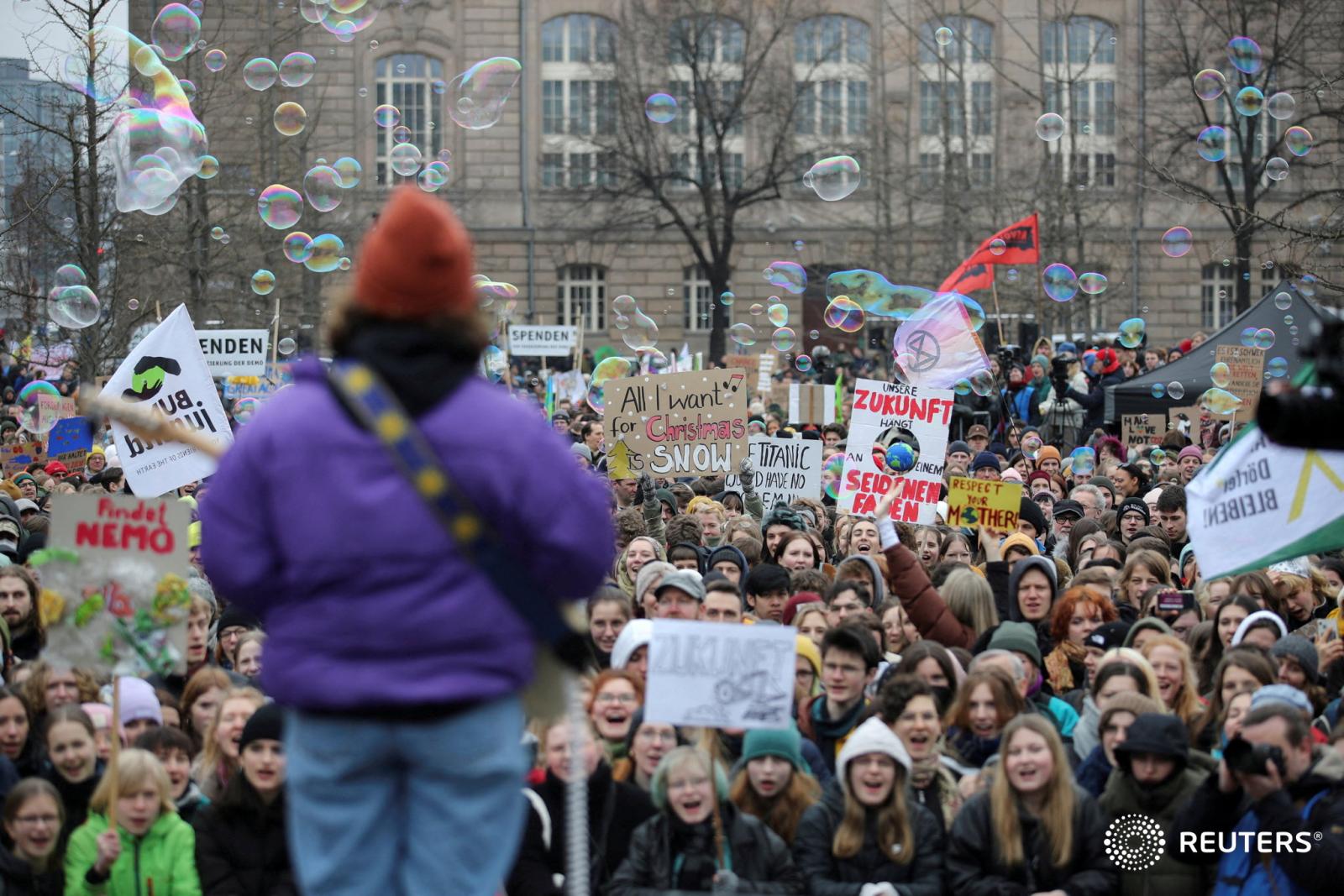 Fridays For Future calls for global climate strike for Reuters - Demonstrators react as a musician soundchecks for a...