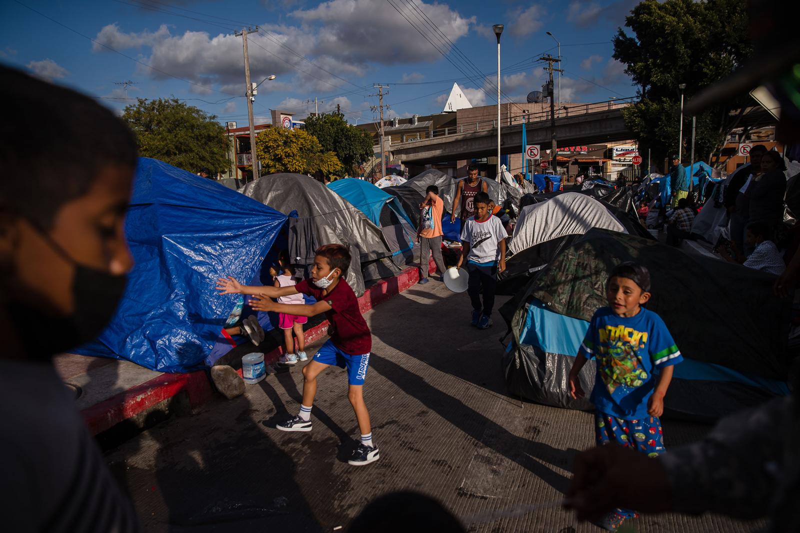 Children play at El Chaparral plaza in Tijuana, Mexico on March 21, 2021. Hundreds of asylum seekers have set up tents near the port of entry in hopes of being able to seek asylum in the United States.