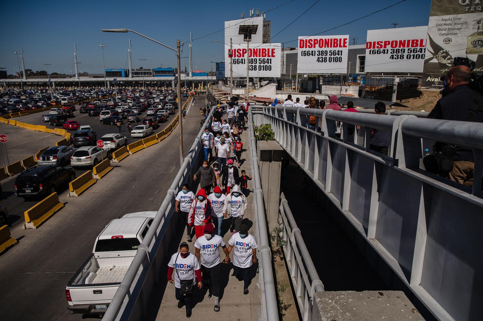 Asylum seekers march to the San Ysidro crossing port in Tijuana, Mexico on March 2, 2021.