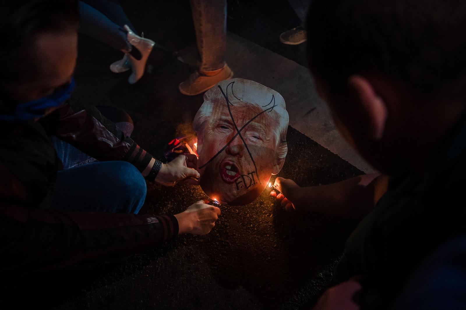 Men set a cardboard cutout on fire of President Donald Trump on November 7, 2020 in San Diego, California. &nbsp;After days of waiting for the election results to be counted, it was announced earlier in the day that Joe Biden defeated President Trump.