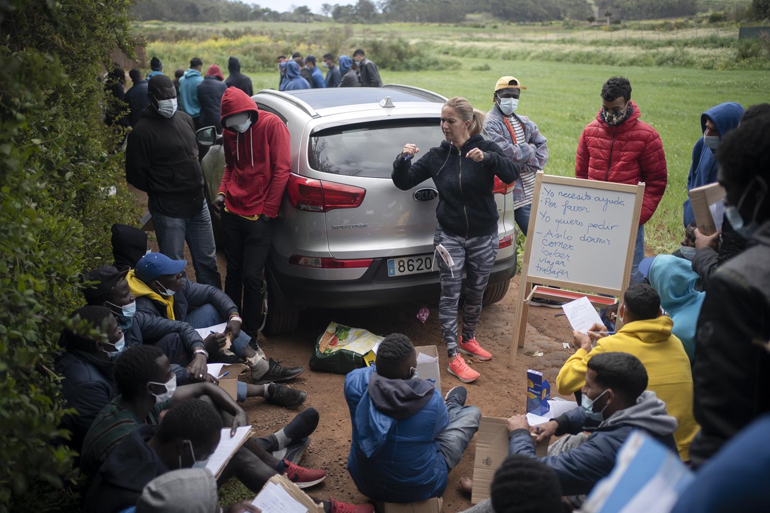 Las Raí­ces Camp - A resident from Tenerife teaches Spanish to migrants from...