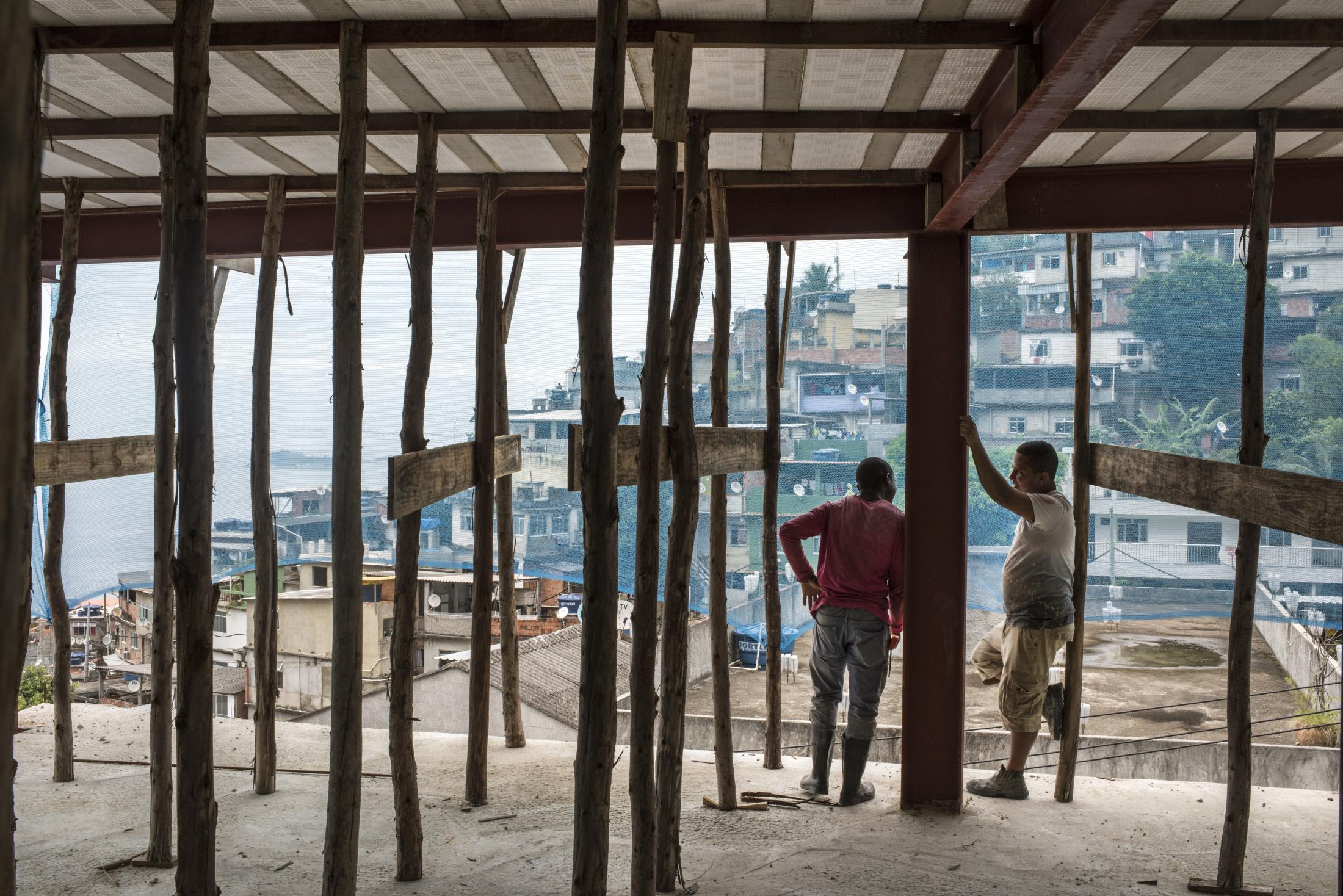 Vidigal - Workers chat at the construction site of a new commercial...