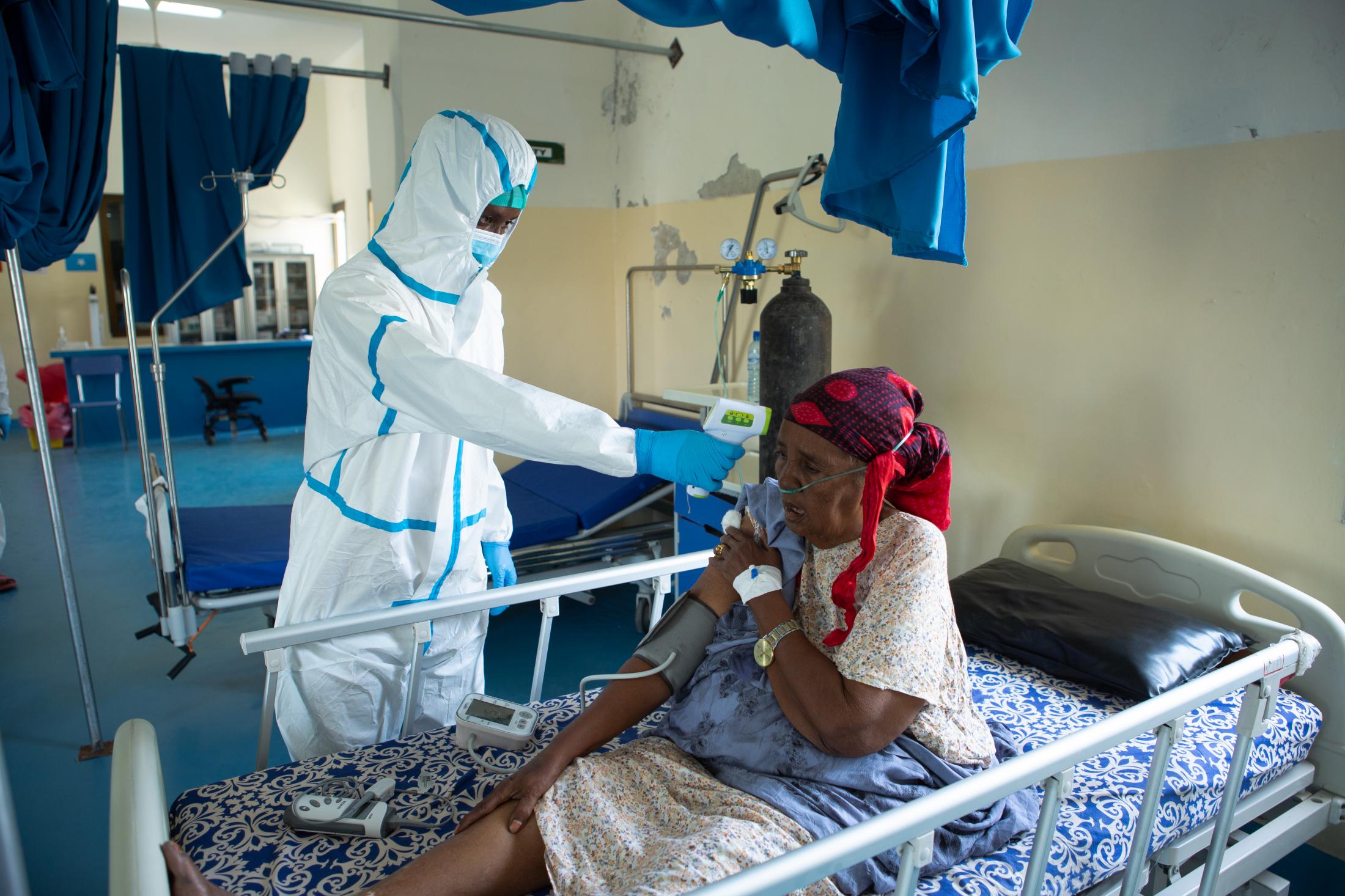 A day at a COVID -19 treatment centre in Somalia - Nurse Liban Adan checks the temperature of an elderly...