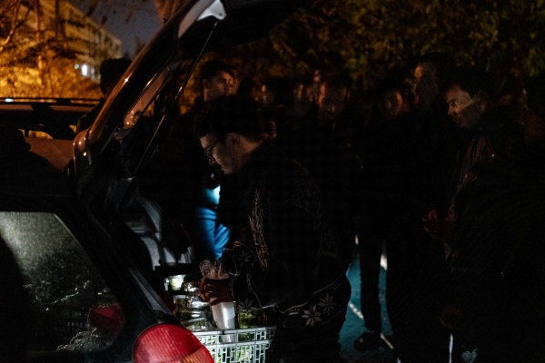HIDDEN BEHIND THE RAILROAD - Homeless refugees gathers around one of the cars of the...