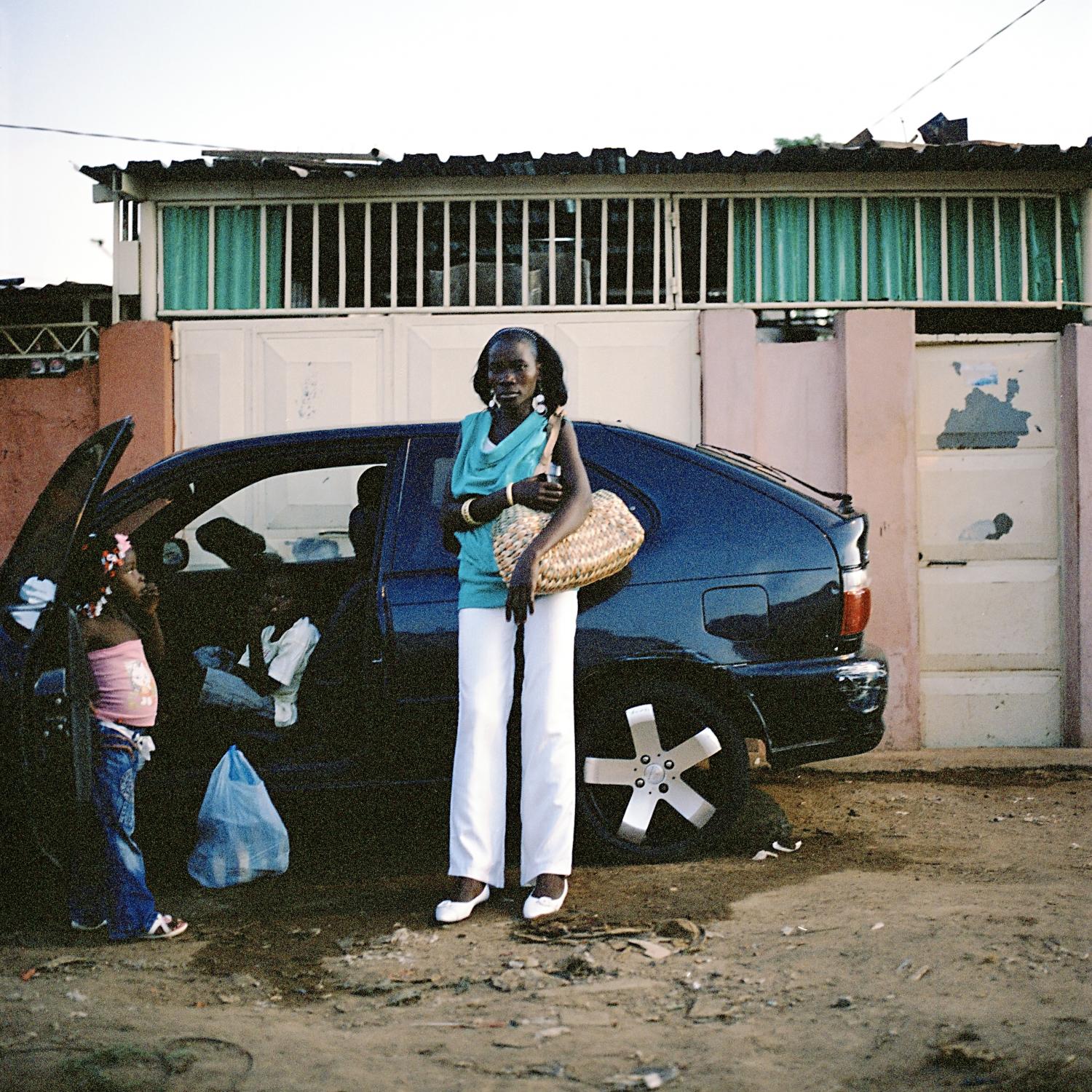 Angola - A woman with her kids outside her home in Marçal,...