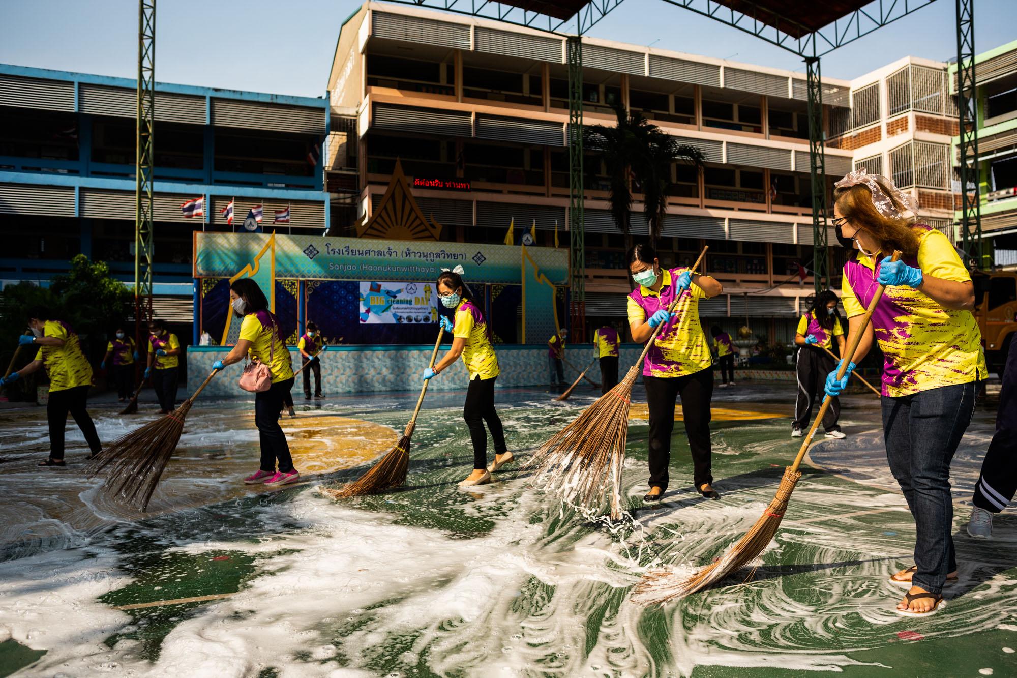 Covid-19: Thailand - Government workers and volunteers clean a playground area...