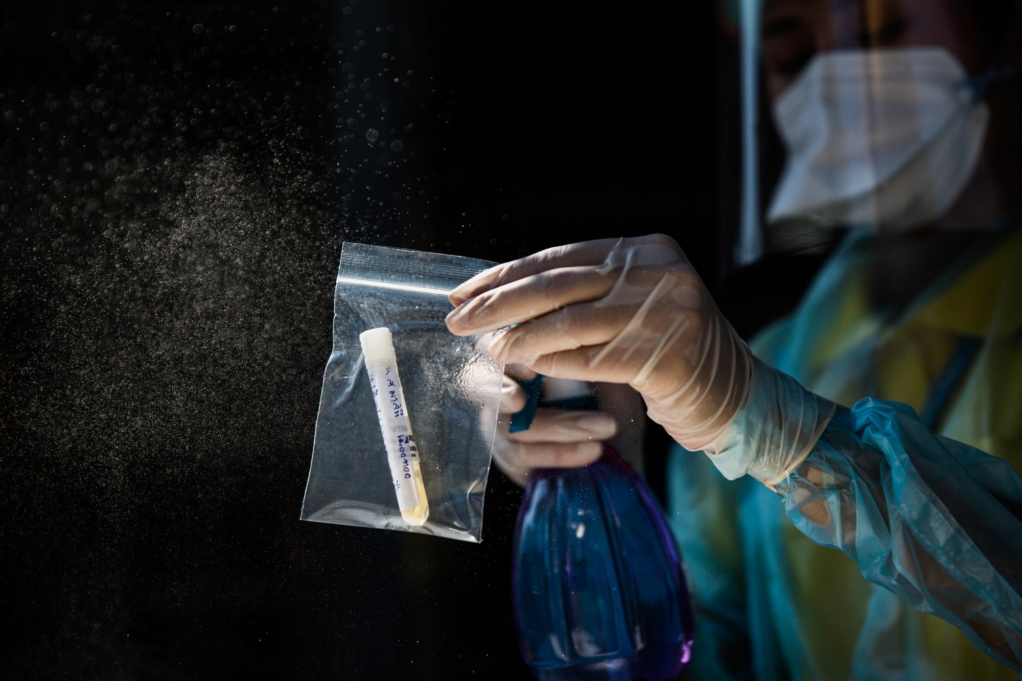 Covid-19: Thailand - A health worker disinfects a Covid-19 swab test sample...