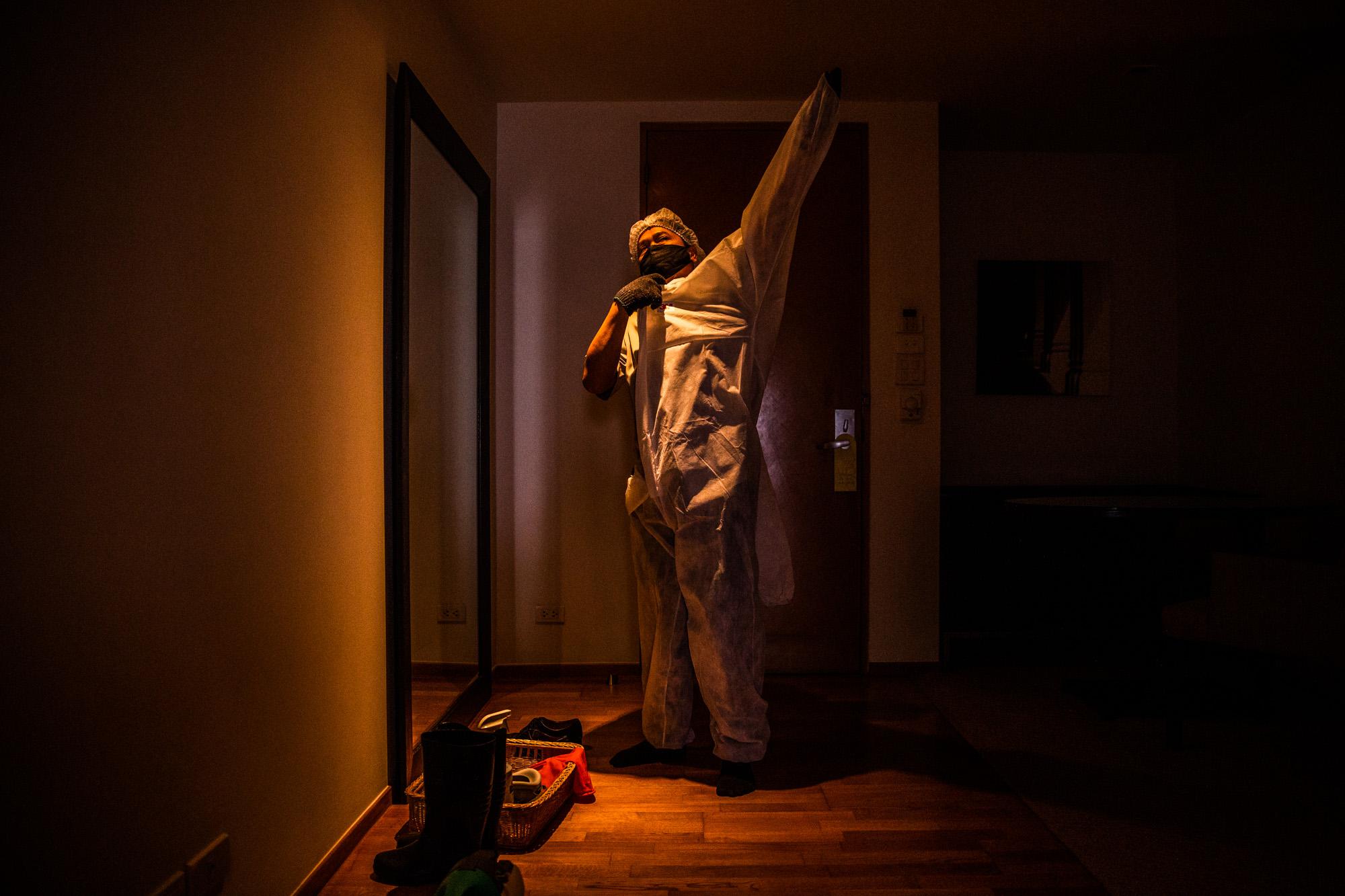 Covid-19: Thailand - A hotel staffer puts on PPE before sterilizing a room to...