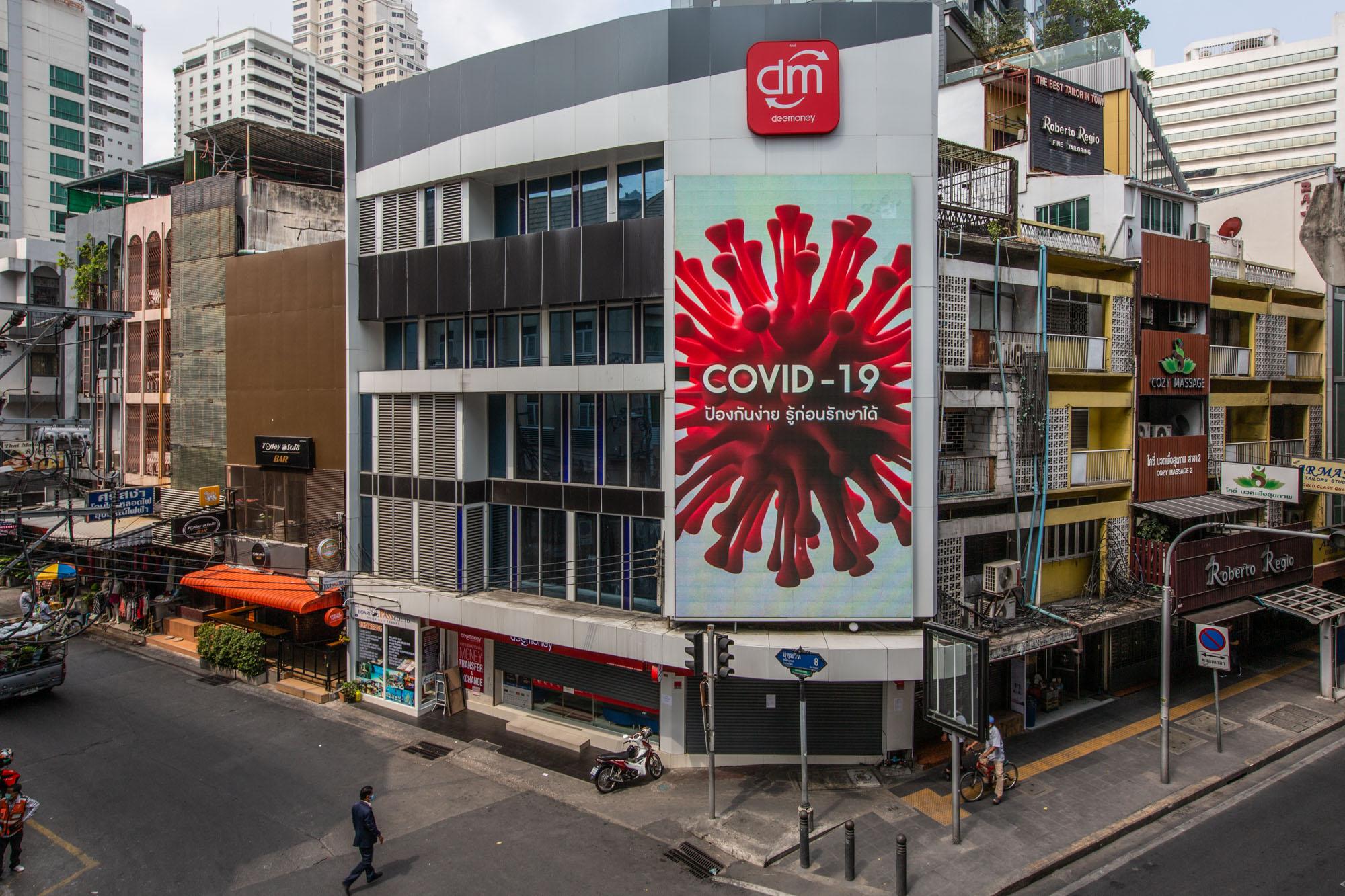 Covid-19: Thailand - A screen displays a Covid-19 virus graphic on Sukhumvit...