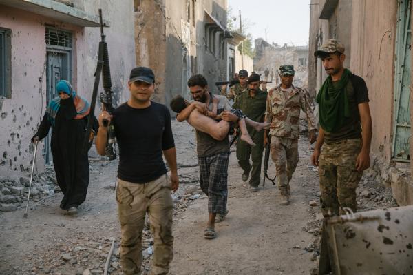Mossul Ouest le 5 juillet 2017, Des hommes et des femmes fuient les combats de la vieille ville. Ici un homme et son fils blessÃ©. Ils se trouvent au bord du Tigre et se dirigent vers la 9eme division de l'armÃ©e irakienne.