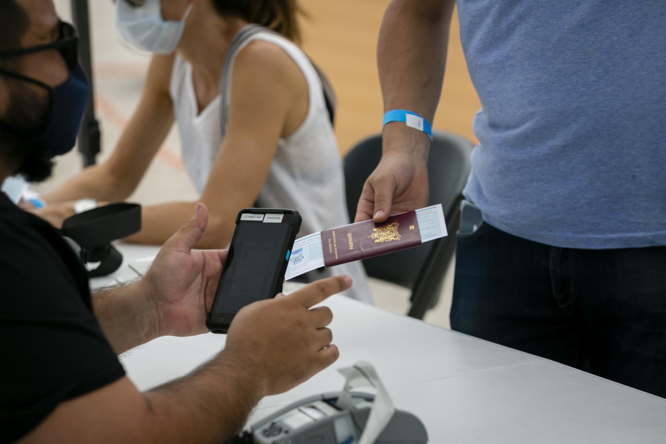 2021 - Tourists get Johnson & Johnson COVID-19 vaccine at Miami Beach - A man gives his passport for registration  to get Johnson...