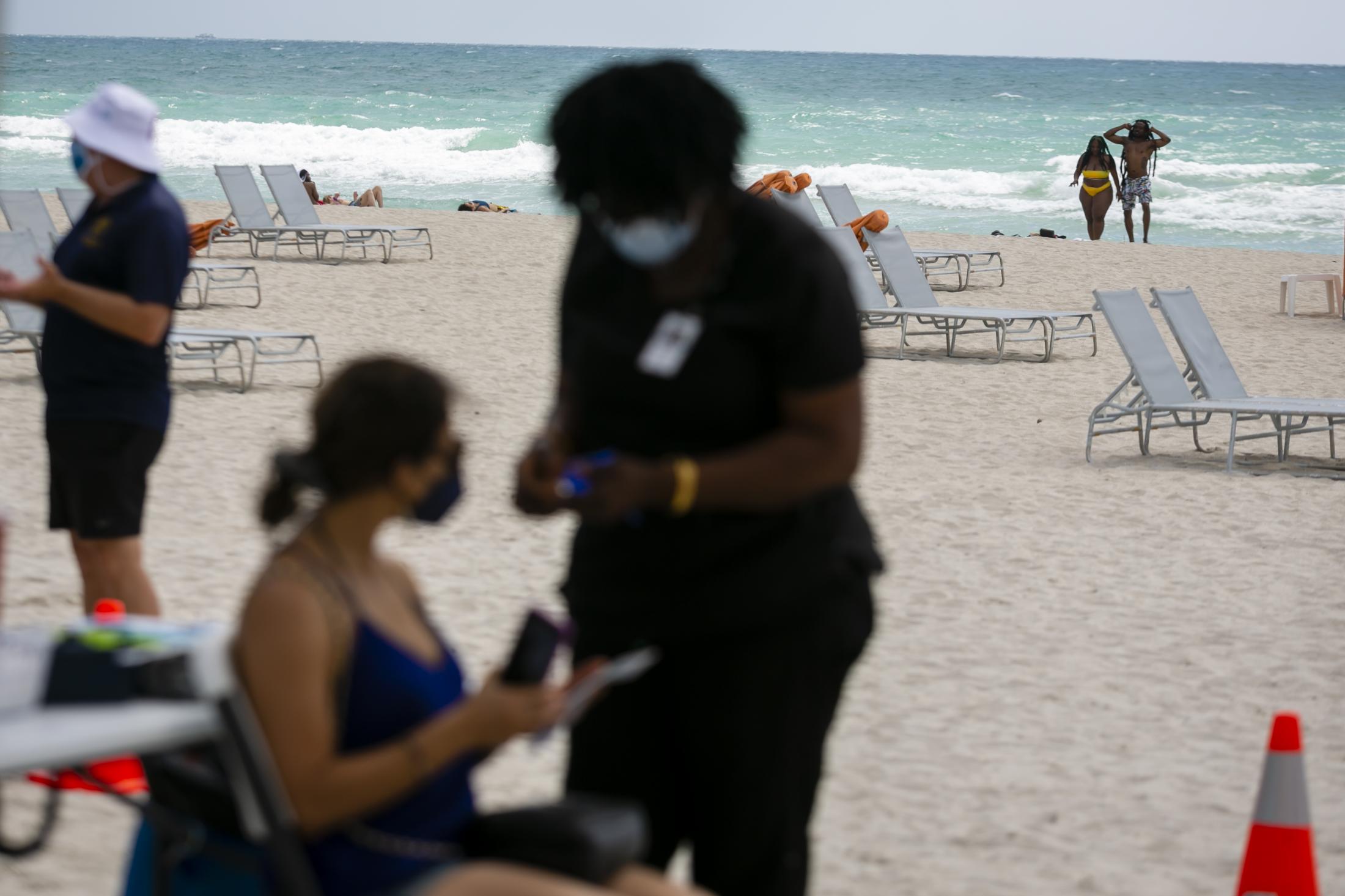 2021 - Tourists get Johnson & Johnson COVID-19 vaccine at Miami Beach - Beachgoers are seen in front of a pop-up vaccination...