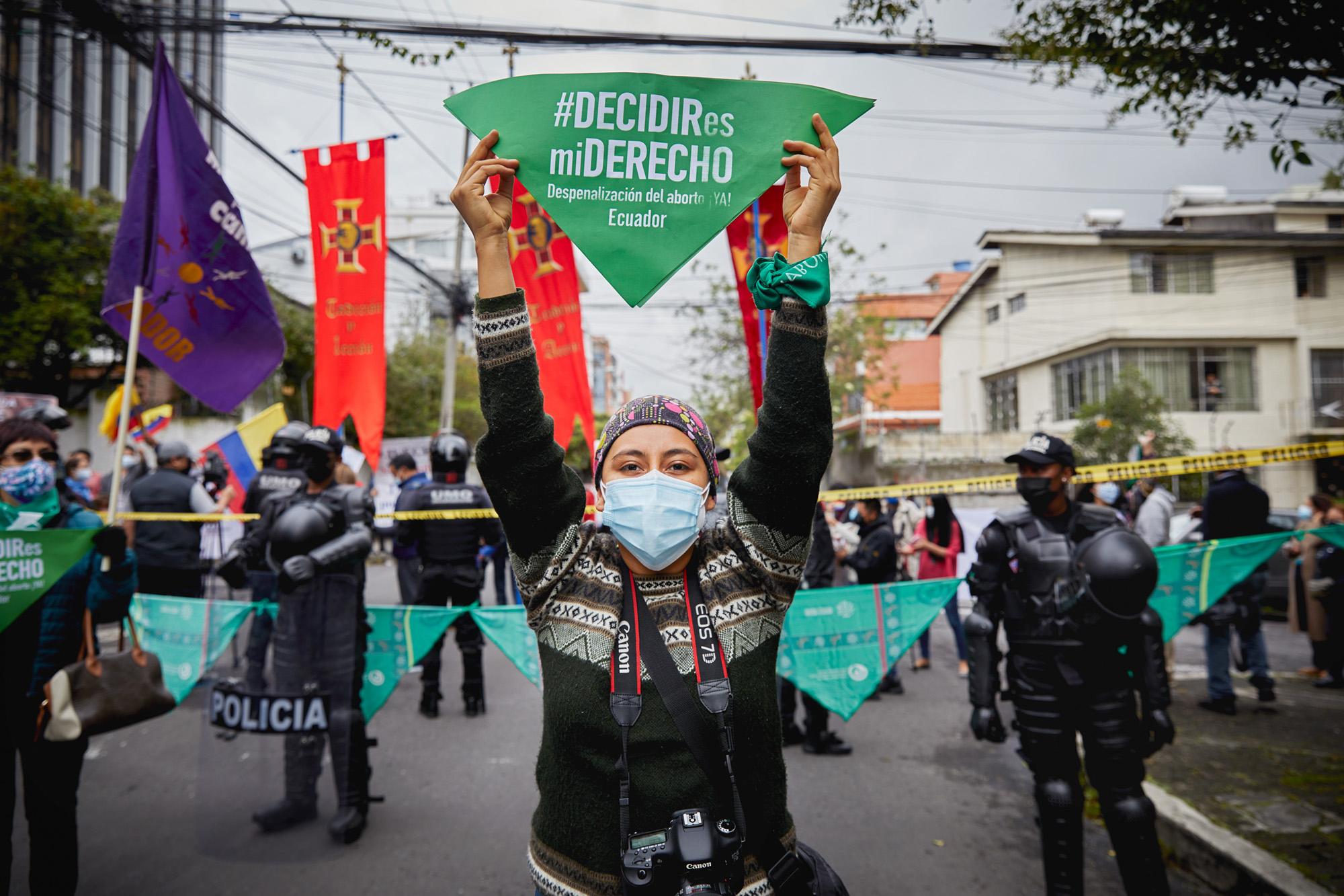 A young woman holds a sign that reads &quot;Decidir es mi derecho&quot; (To decide is my right), behind her are police and anti-rights groups called &quot;pro-life&quot;. On this historic day for Ecuador, the Constitutional Court issued a ruling that decriminalizes abortion in cases of rape for any woman or girl. In Ecuador more than 2000 girls a year become pregnant after rape. April 28, 2021, Quito, Ecuador.