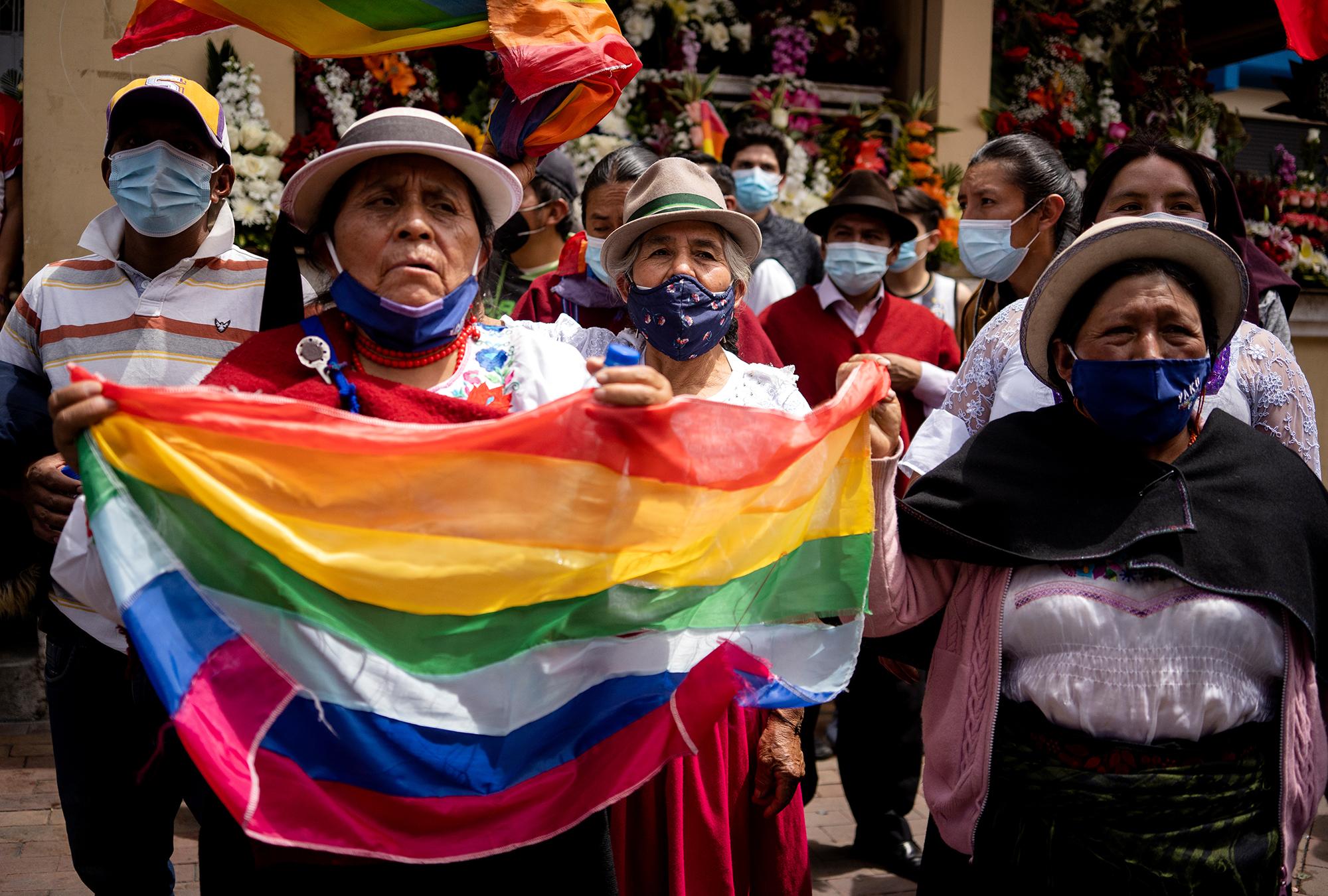 Indigenous women hold the Pachacutik party flag while waiting for the National March for...